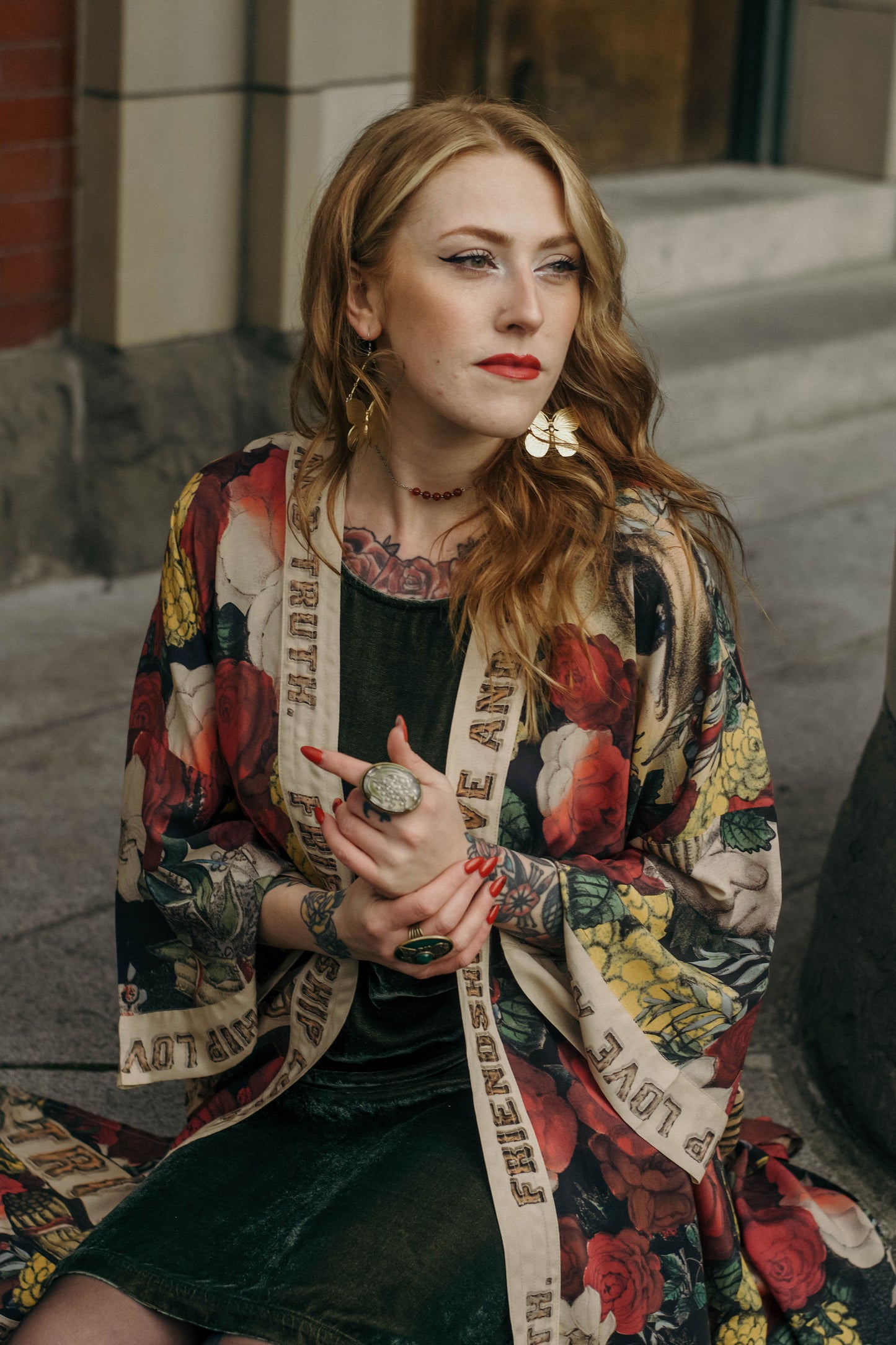 Model wearing our long, eclectic opera duster featuring vintage symbols of love, kindness, and truth in a bold archive-inspired print with removable belt – Market of Stars.