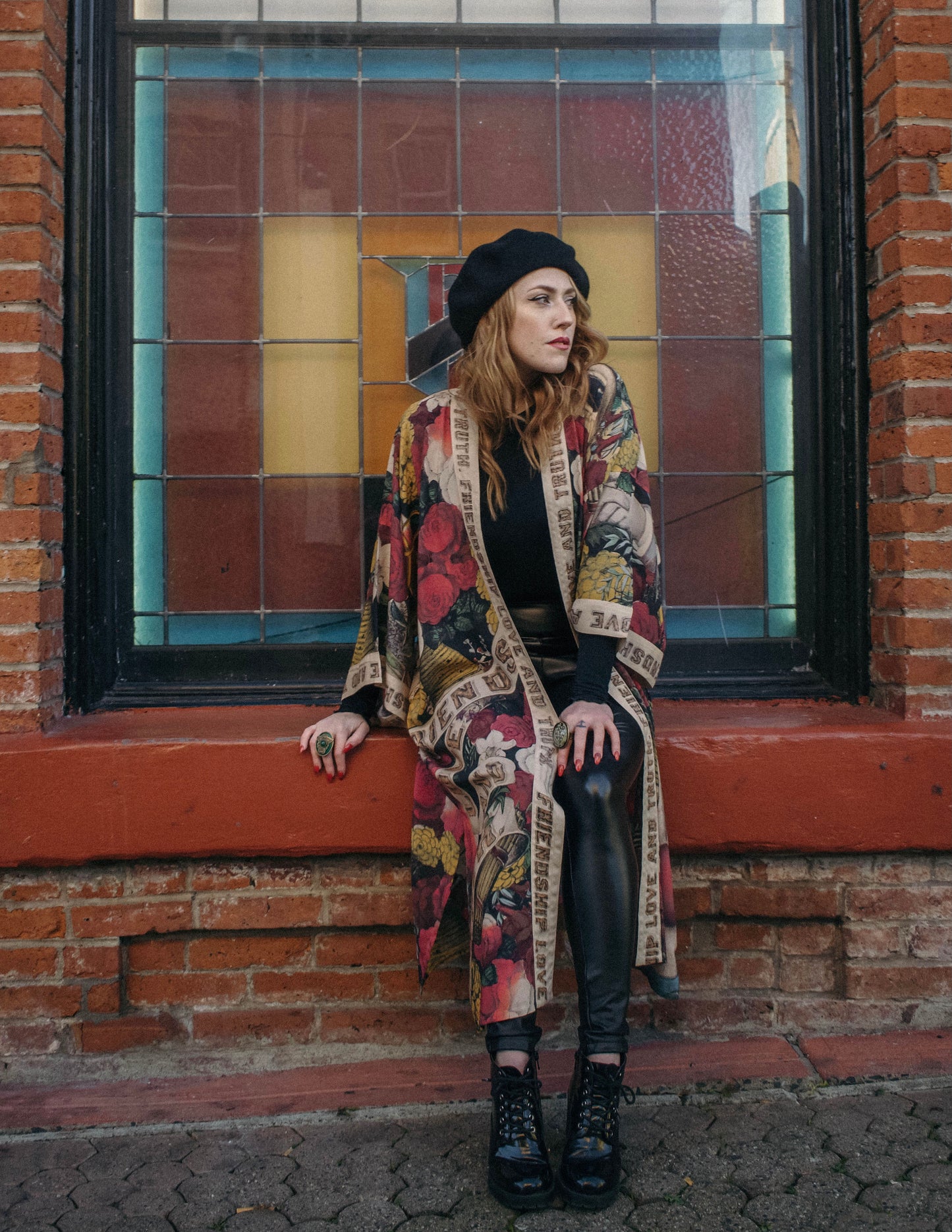 Model wearing our long, eclectic opera duster featuring vintage symbols of love, kindness, and truth in a bold archive-inspired print with removable belt – Market of Stars.