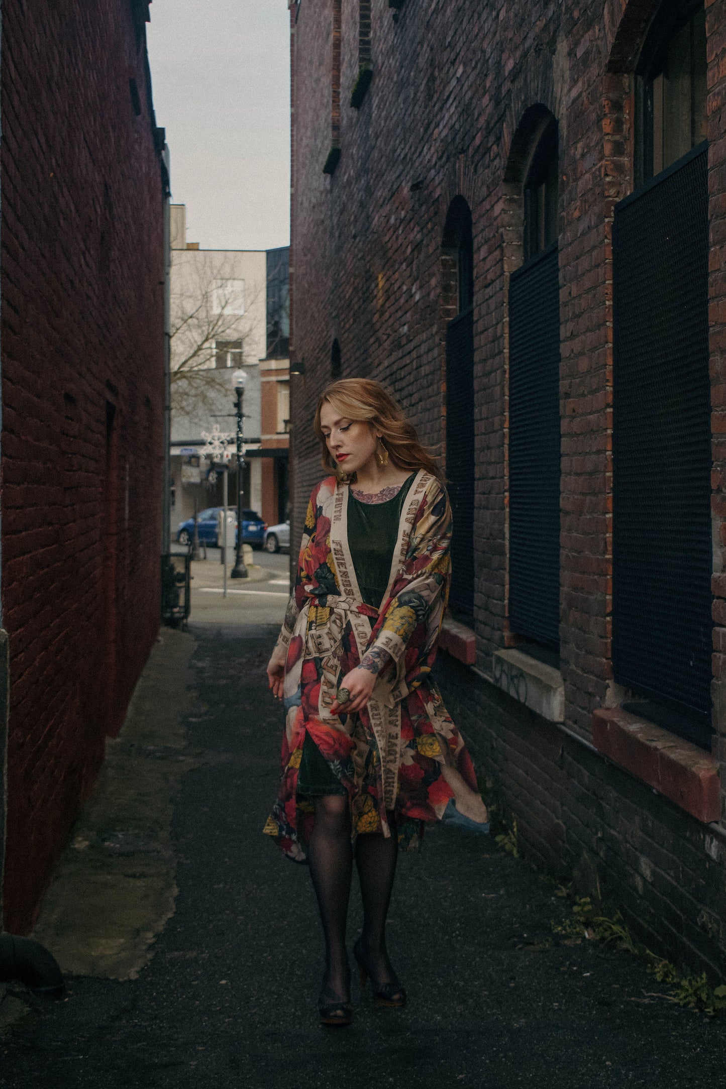 Model wearing our long, eclectic opera duster featuring vintage symbols of love, kindness, and truth in a bold archive-inspired print with removable belt – Market of Stars.