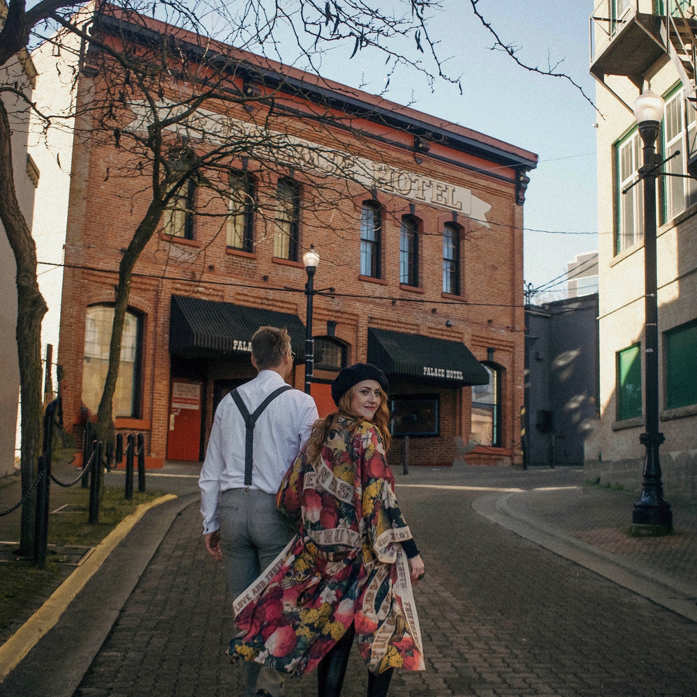 
                  
                    Model wearing our long, eclectic opera duster featuring vintage symbols of love, kindness, and truth in a bold archive-inspired print with removable belt – Market of Stars.
                  
                
