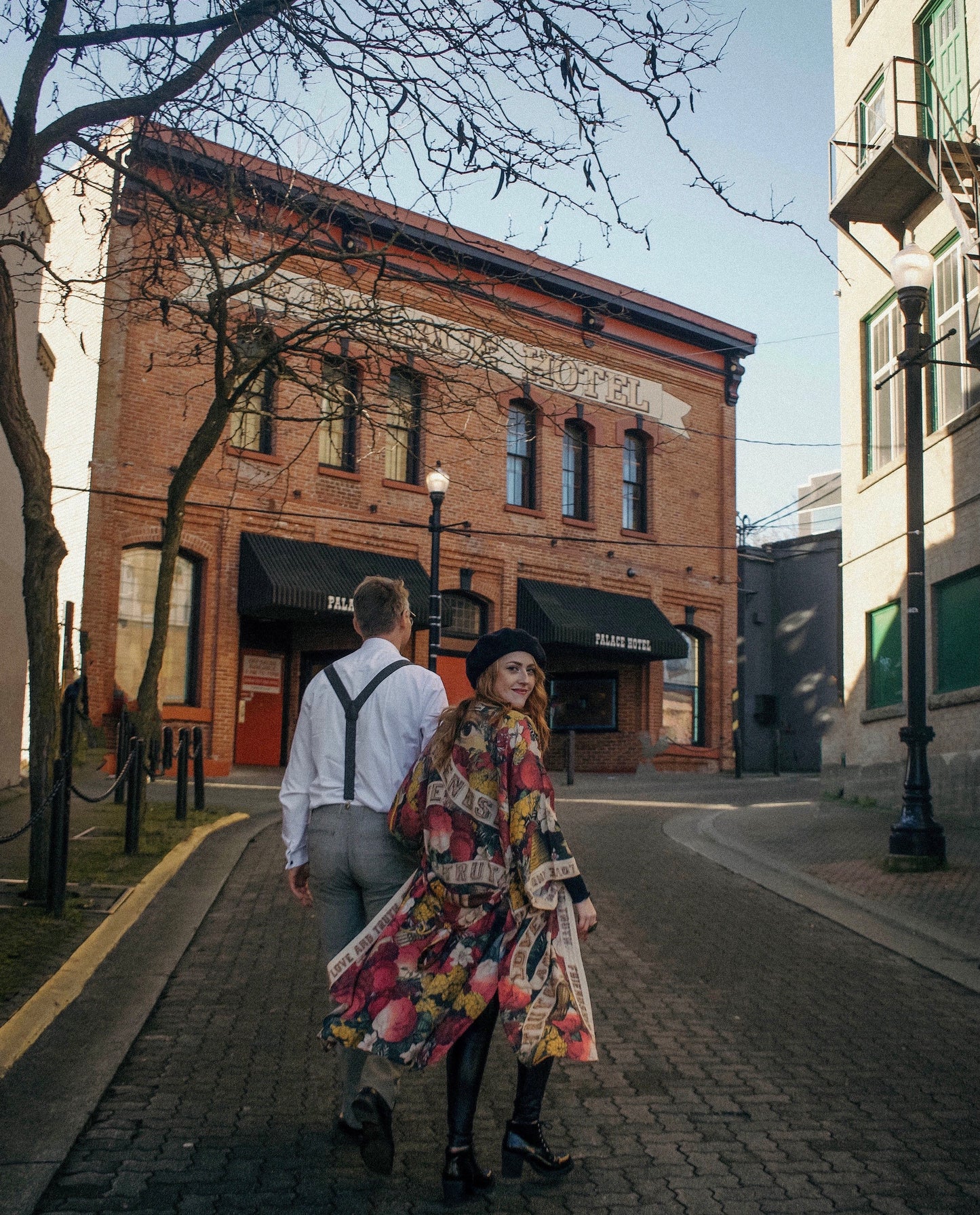 Model wearing our long, eclectic opera duster featuring vintage symbols of love, kindness, and truth in a bold archive-inspired print with removable belt – Market of Stars.