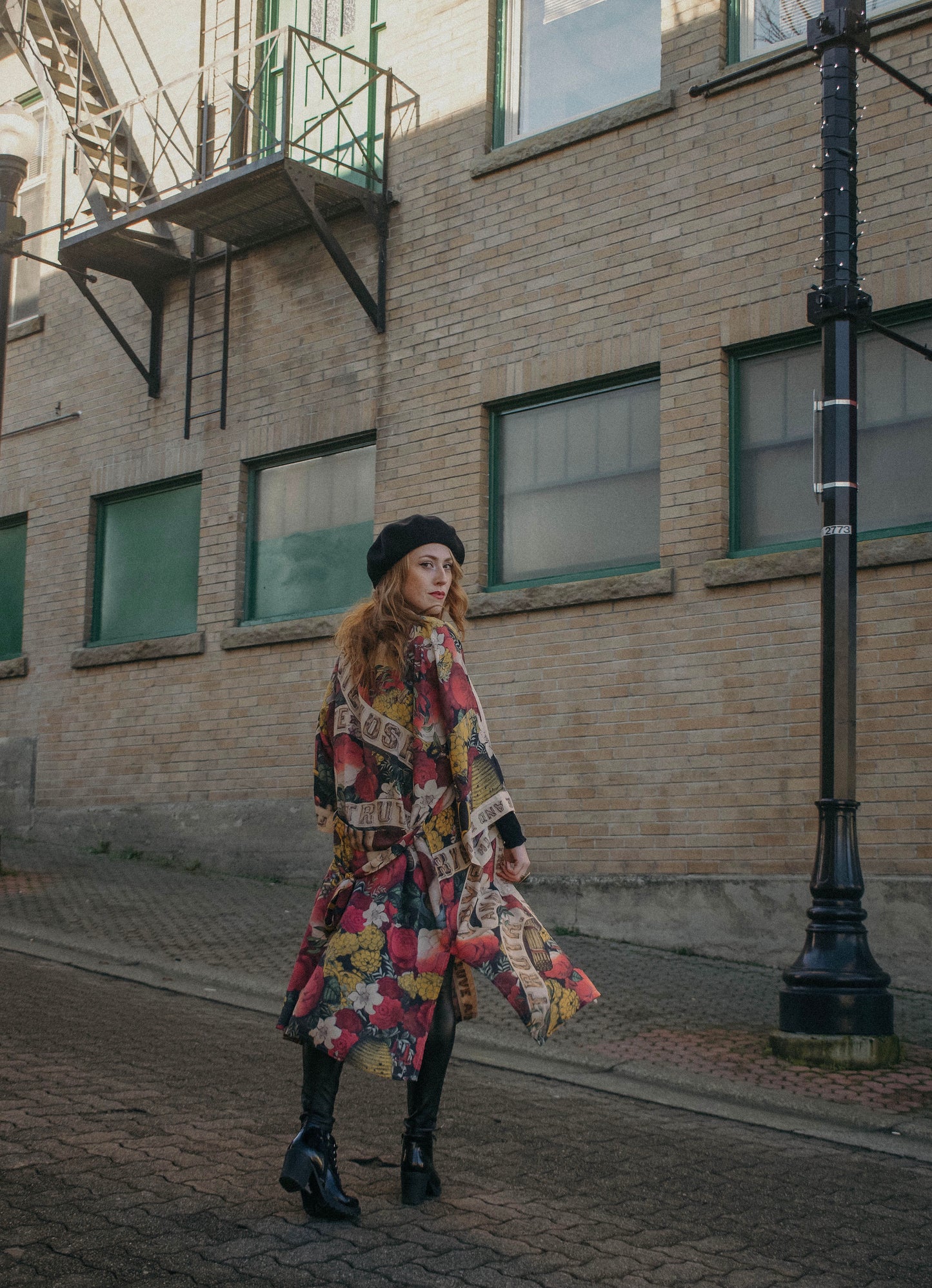 Model wearing our long, eclectic opera duster featuring vintage symbols of love, kindness, and truth in a bold archive-inspired print with removable belt – Market of Stars.