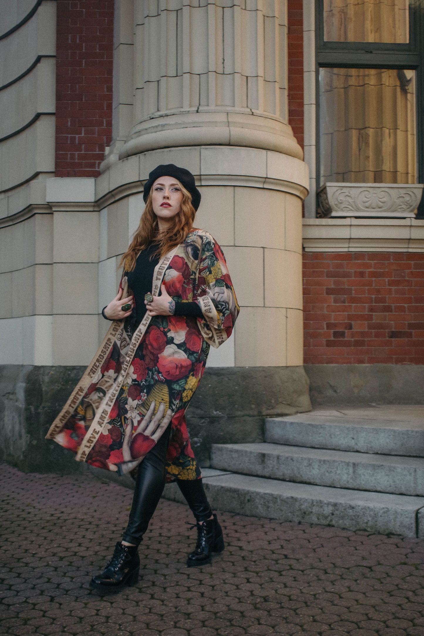 Model wearing our long, eclectic opera duster featuring vintage symbols of love, kindness, and truth in a bold archive-inspired print with removable belt – Market of Stars.