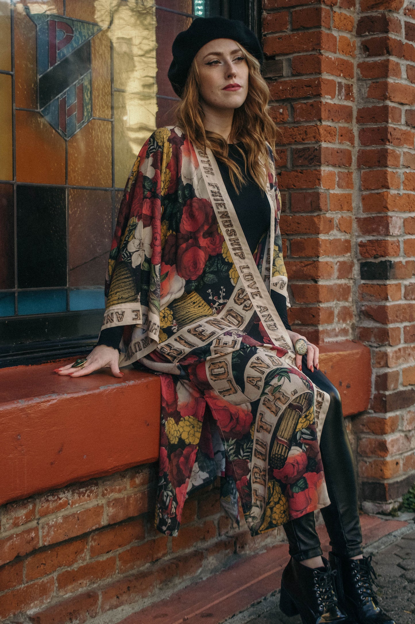 Model wearing our long, eclectic opera duster featuring vintage symbols of love, kindness, and truth in a bold archive-inspired print with removable belt – Market of Stars.