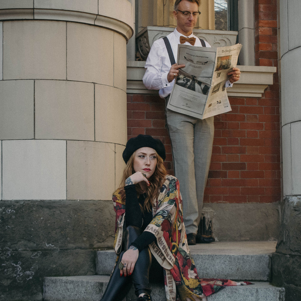 
                  
                    Model wearing our long, eclectic opera duster featuring vintage symbols of love, kindness, and truth in a bold archive-inspired print with removable belt – Market of Stars.
                  
                