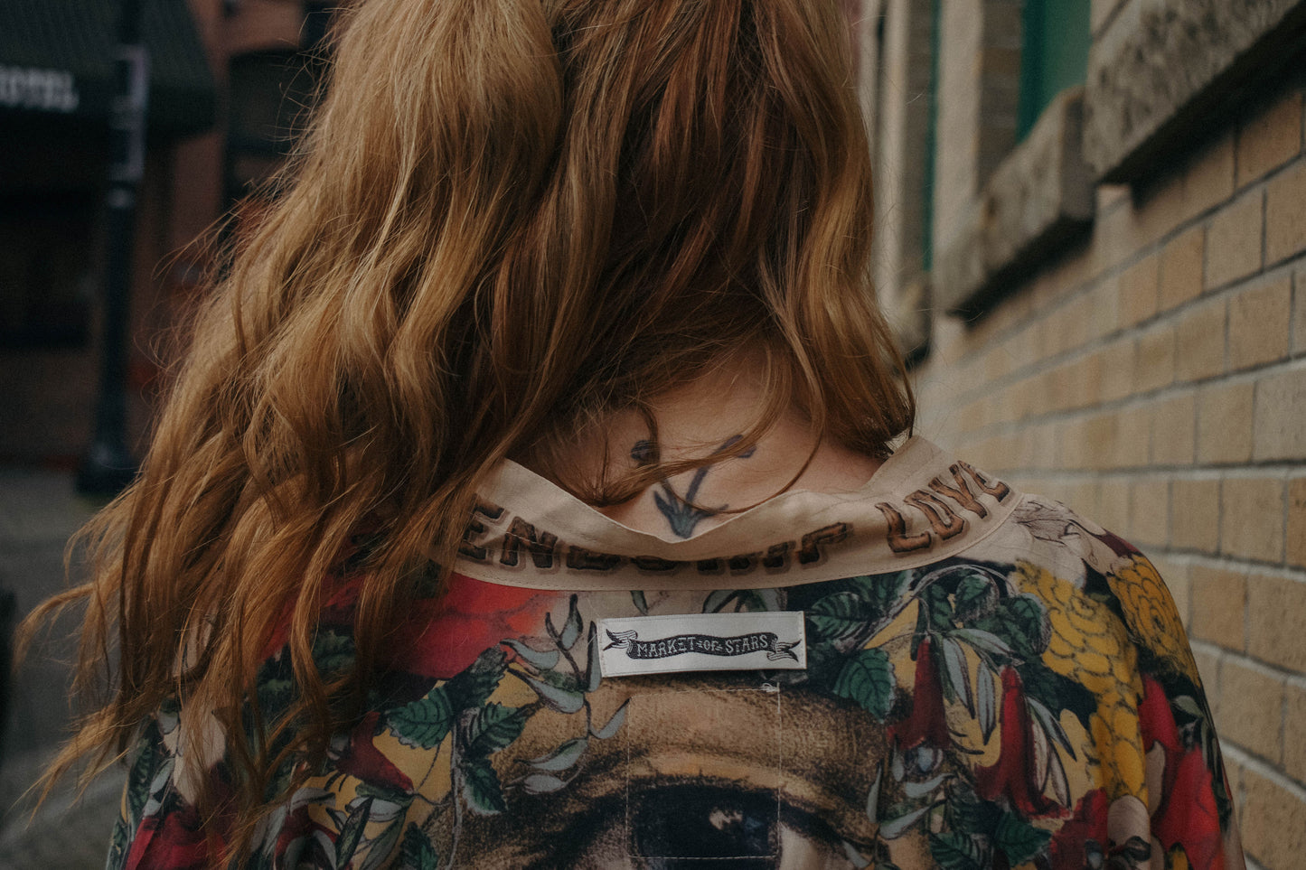 Model wearing our long, eclectic opera duster featuring vintage symbols of love, kindness, and truth in a bold archive-inspired print with removable belt – Market of Stars.