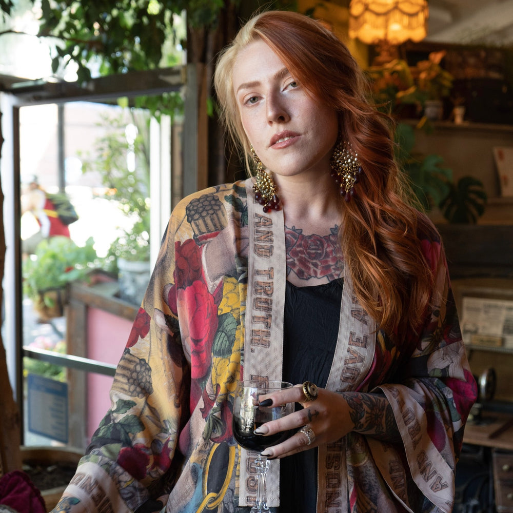
                  
                    Model wearing our cropped kimono featuring historic symbols of friendship, love, and truth with archive-inspired wood-grain trim and romantic vintage details – Market of Stars.
                  
                