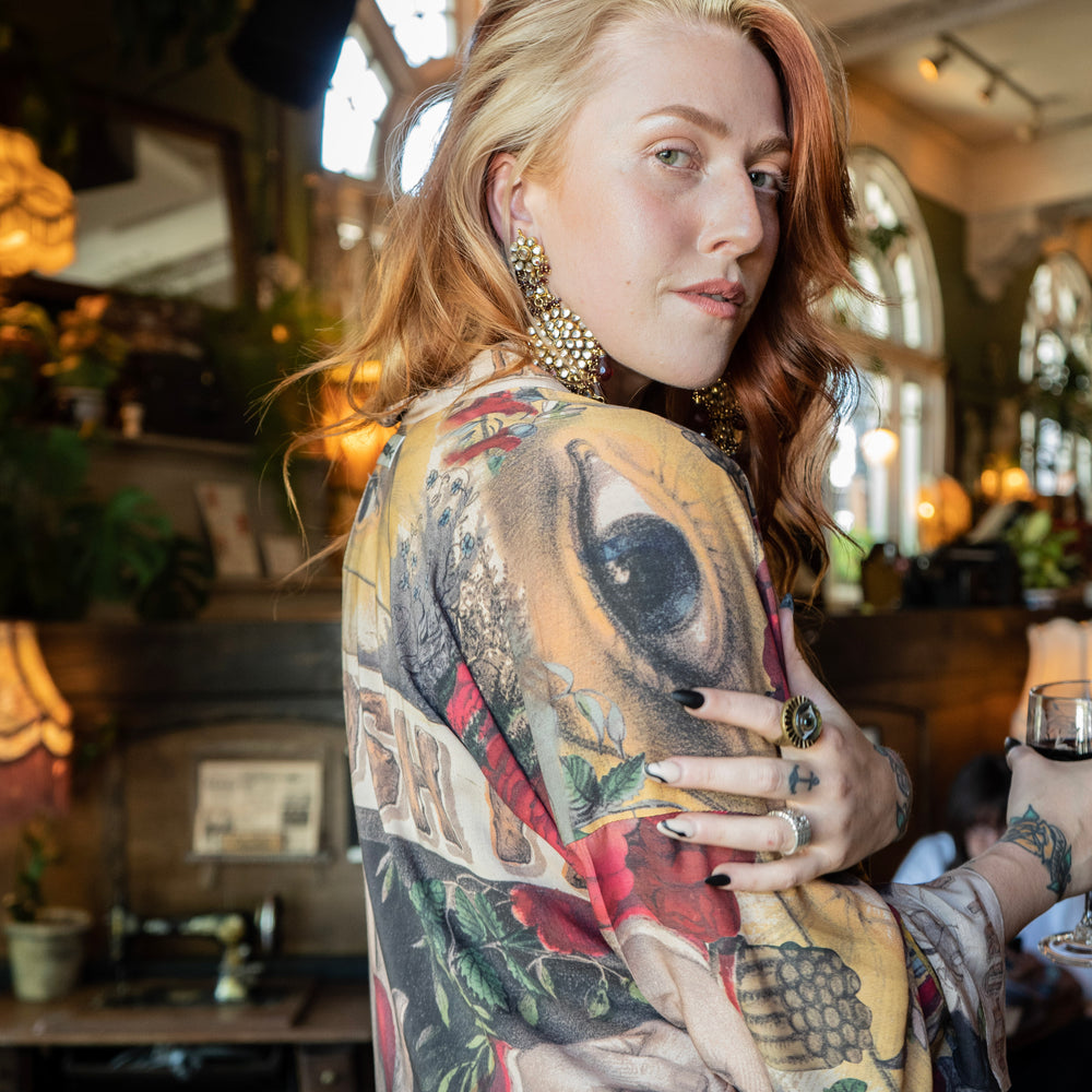 
                  
                    Model wearing our cropped kimono featuring historic symbols of friendship, love, and truth with archive-inspired wood-grain trim and romantic vintage details – Market of Stars.
                  
                