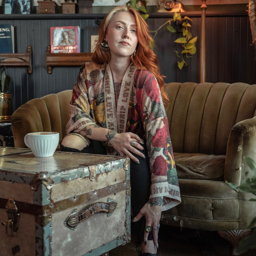 
                  
                    Model wearing our cropped kimono featuring historic symbols of friendship, love, and truth with archive-inspired wood-grain trim and romantic vintage details – Market of Stars.
                  
                