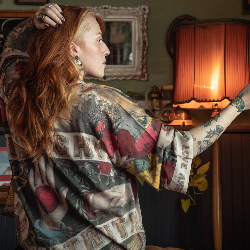 
                  
                    Model wearing our cropped kimono featuring historic symbols of friendship, love, and truth with archive-inspired wood-grain trim and romantic vintage details – Market of Stars.
                  
                