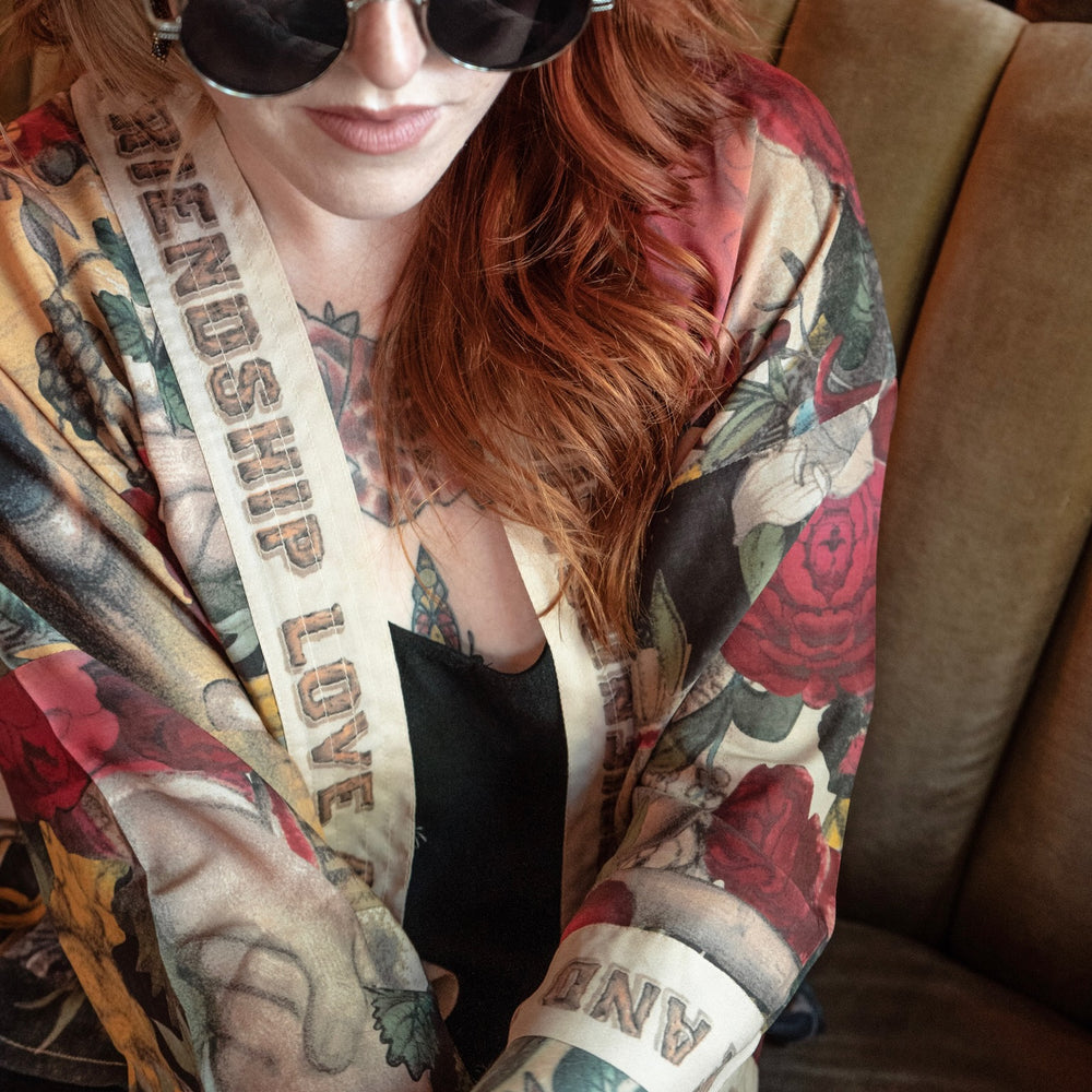 
                  
                    Model wearing our cropped kimono featuring historic symbols of friendship, love, and truth with archive-inspired wood-grain trim and romantic vintage details – Market of Stars.
                  
                