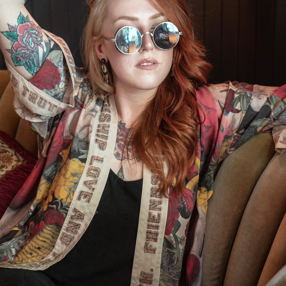 
                  
                    Model wearing our cropped kimono featuring historic symbols of friendship, love, and truth with archive-inspired wood-grain trim and romantic vintage details – Market of Stars.
                  
                