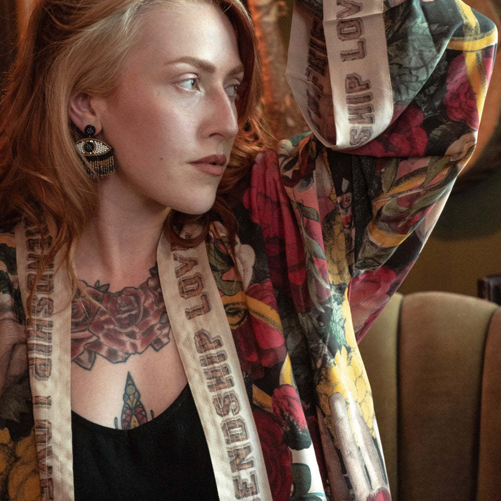 
                  
                    Model wearing our cropped kimono featuring historic symbols of friendship, love, and truth with archive-inspired wood-grain trim and romantic vintage details – Market of Stars.
                  
                