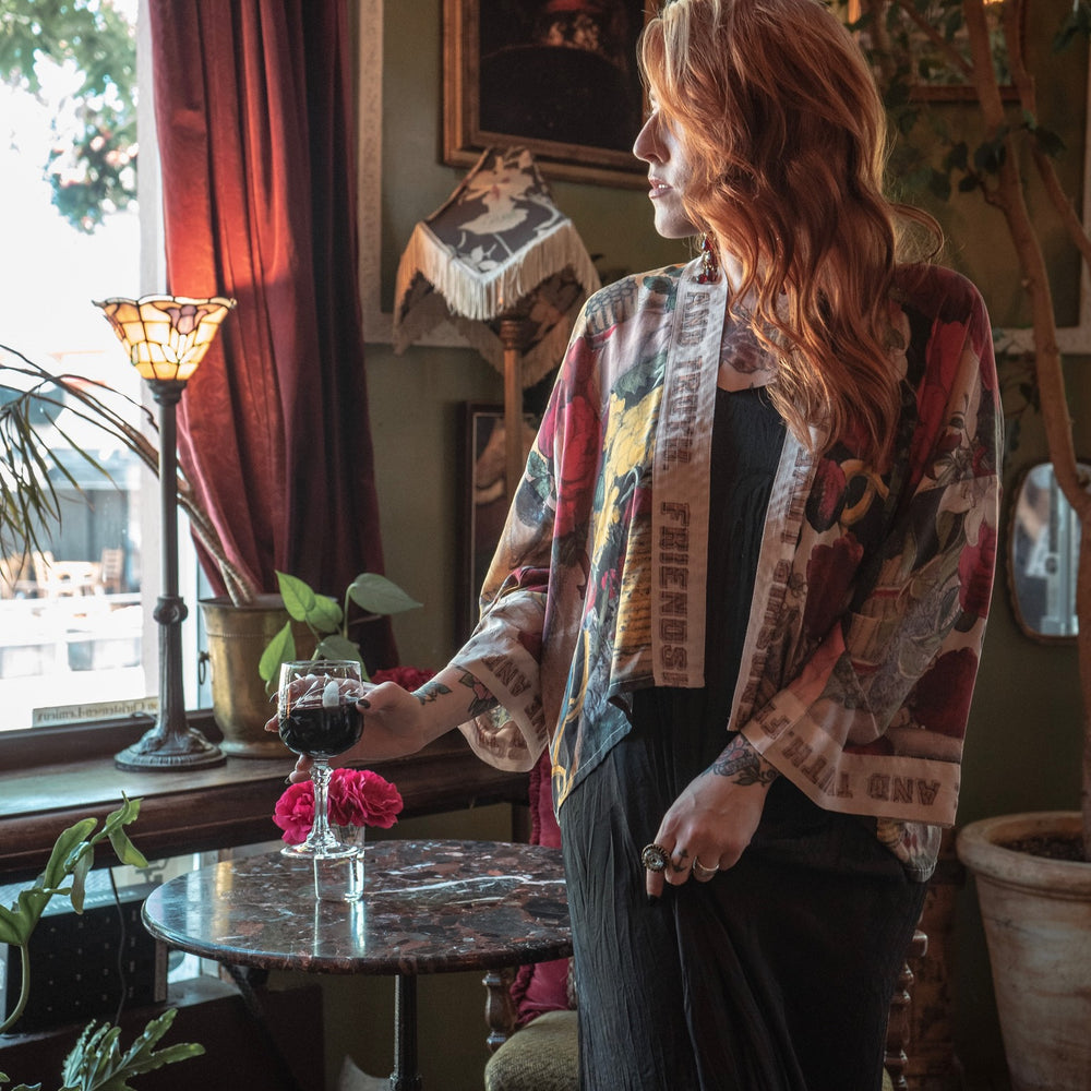 
                  
                    Model wearing our cropped kimono featuring historic symbols of friendship, love, and truth with archive-inspired wood-grain trim and romantic vintage details – Market of Stars.
                  
                