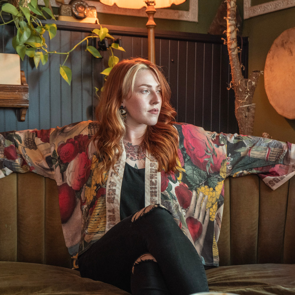 
                  
                    Model wearing our cropped kimono featuring historic symbols of friendship, love, and truth with archive-inspired wood-grain trim and romantic vintage details – Market of Stars.
                  
                