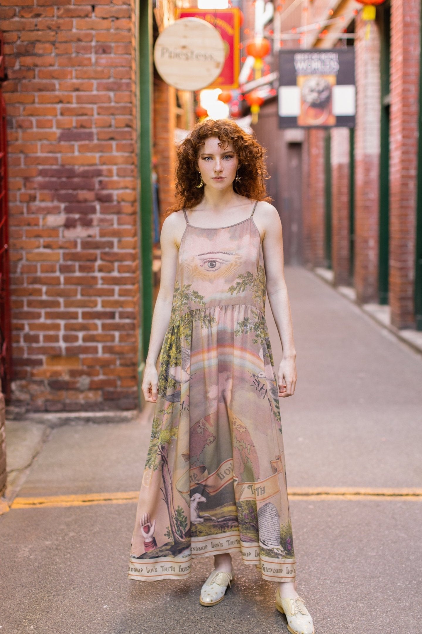 Model wearing sun-washed Bohéme slip dress featuring historic symbols of friendship, love, and truth in soft lavender, sage, gold, and aqua – Market of Stars.