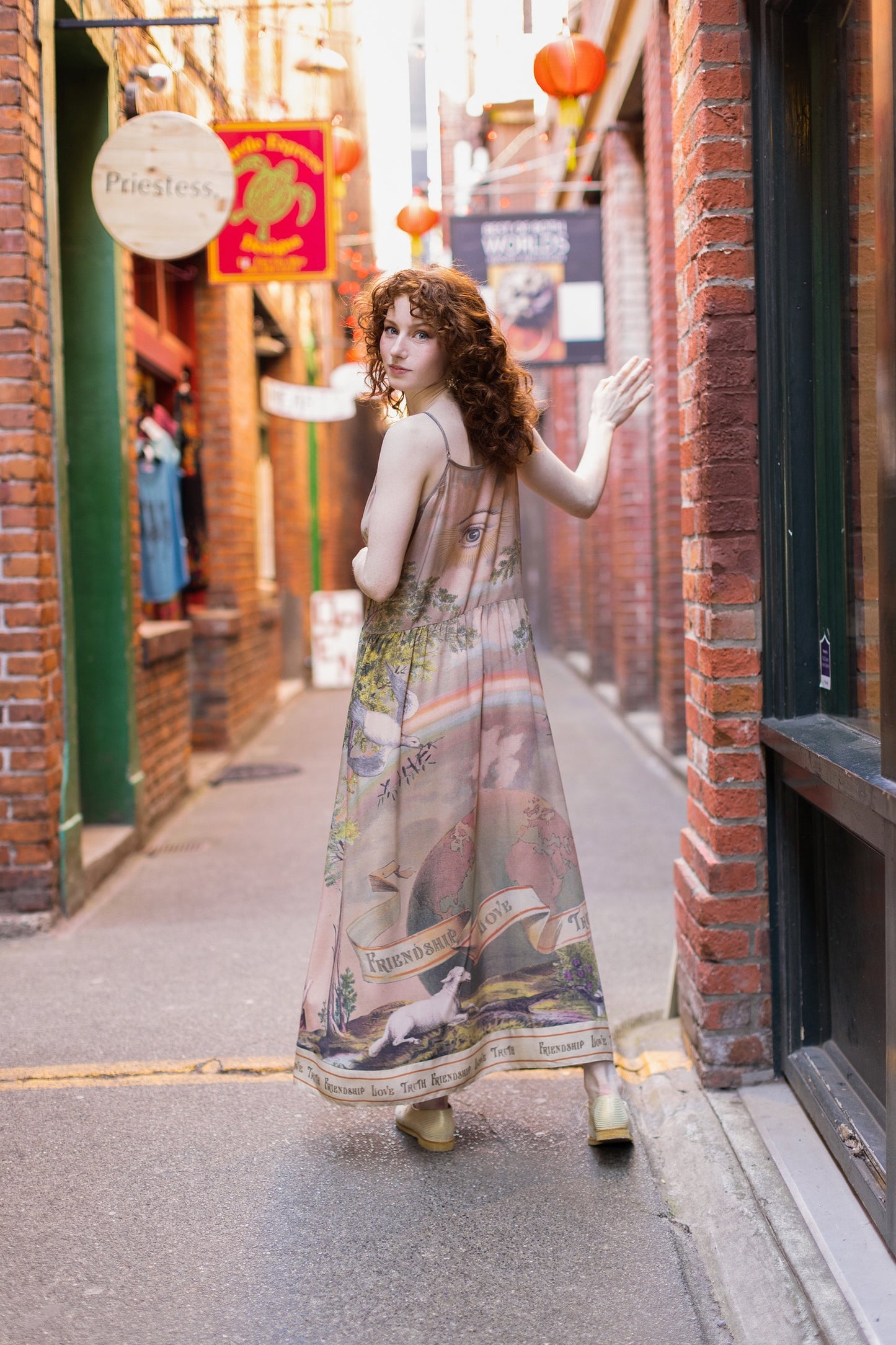 Model wearing sun-washed Bohéme slip dress featuring historic symbols of friendship, love, and truth in soft lavender, sage, gold, and aqua – Market of Stars.