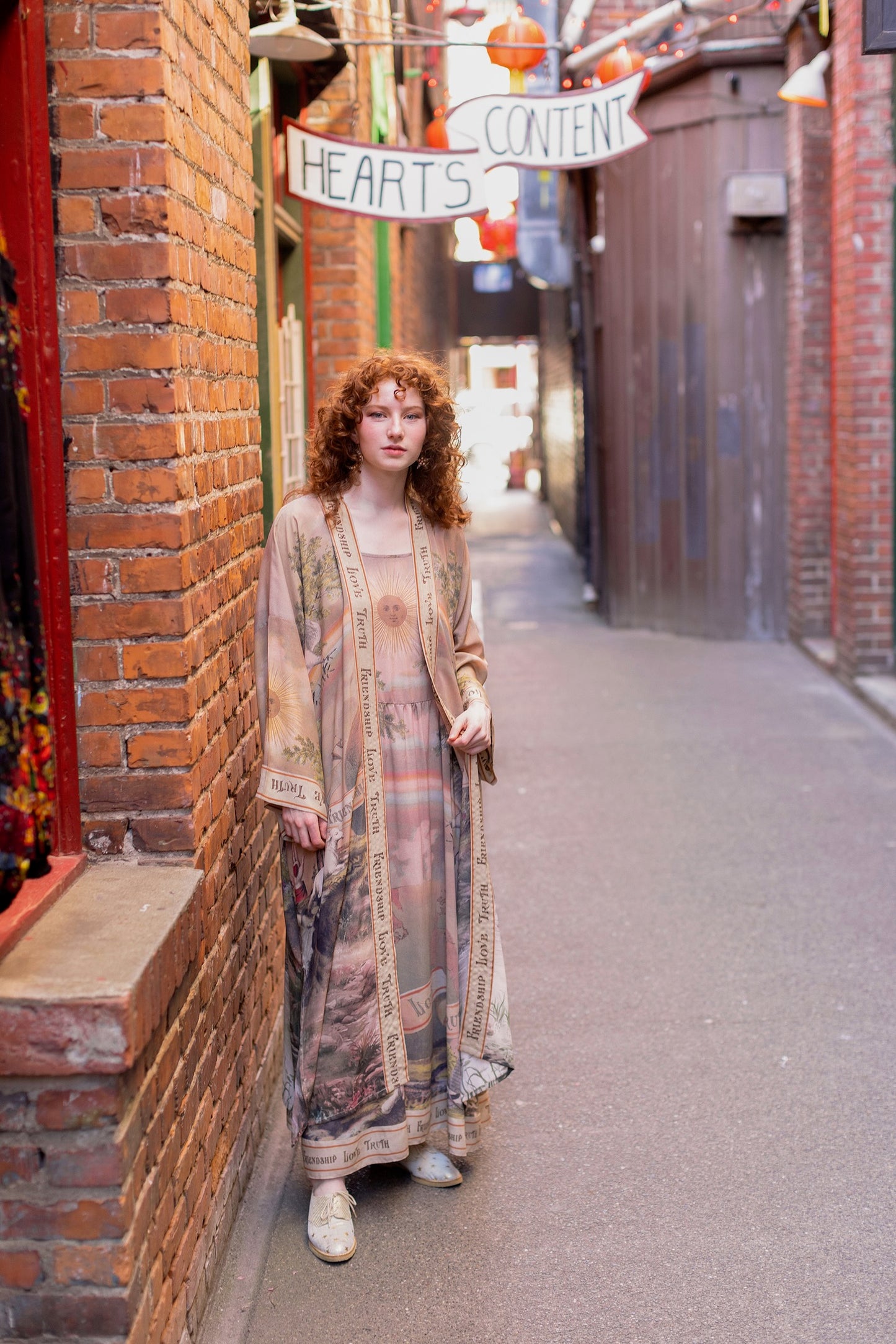 Model wearing sun-washed Bohéme slip dress featuring historic symbols of friendship, love, and truth in soft lavender, sage, gold, and aqua – Market of Stars.