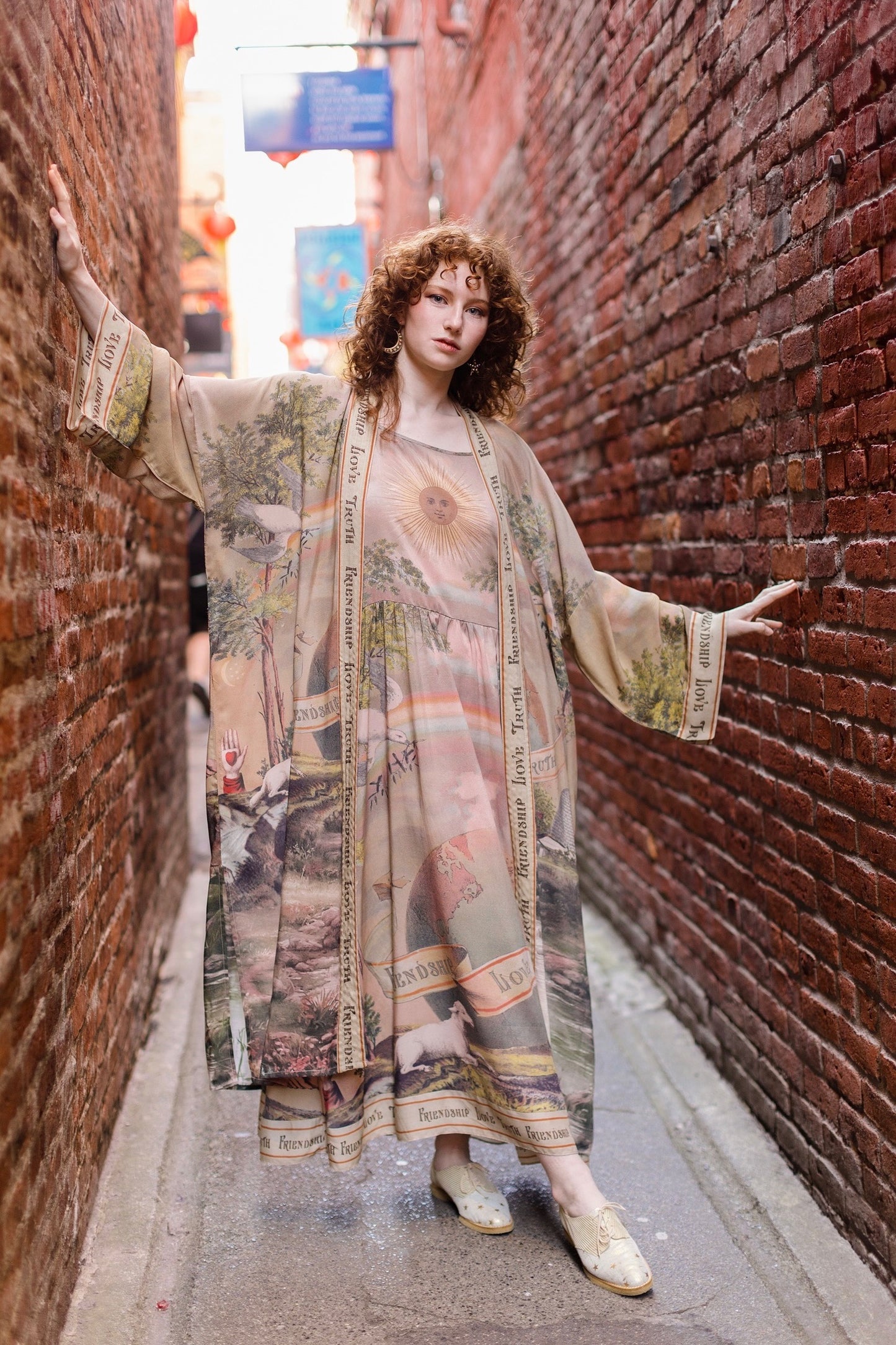 Model wearing sun-washed Bohéme slip dress featuring historic symbols of friendship, love, and truth in soft lavender, sage, gold, and aqua – Market of Stars.