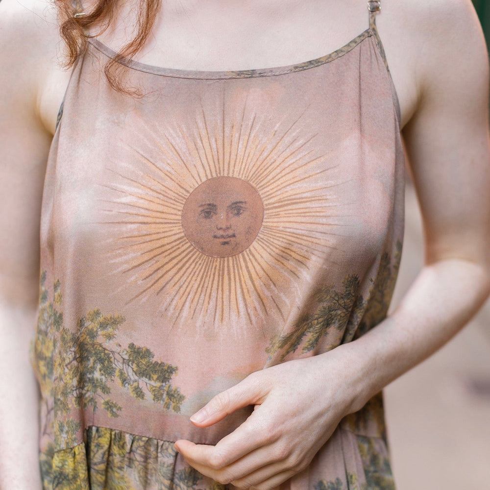 
                  
                    Model wearing sun-washed Bohéme slip dress featuring historic symbols of friendship, love, and truth in soft lavender, sage, gold, and aqua – Market of Stars.
                  
                
