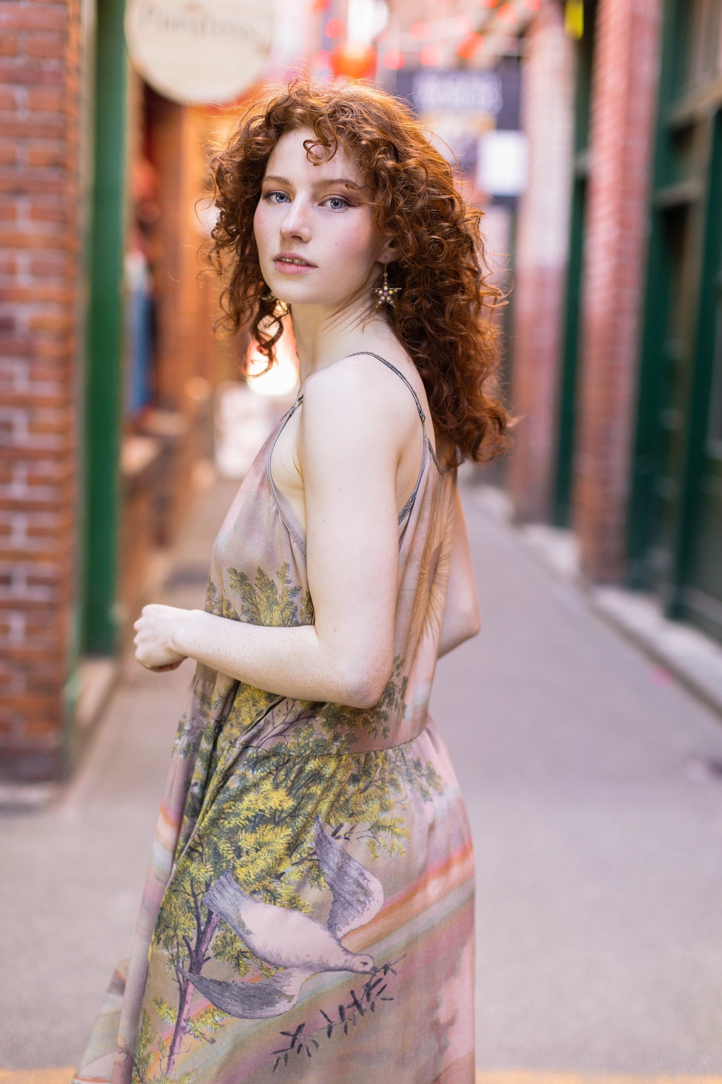 Model wearing sun-washed Bohéme slip dress featuring historic symbols of friendship, love, and truth in soft lavender, sage, gold, and aqua – Market of Stars.