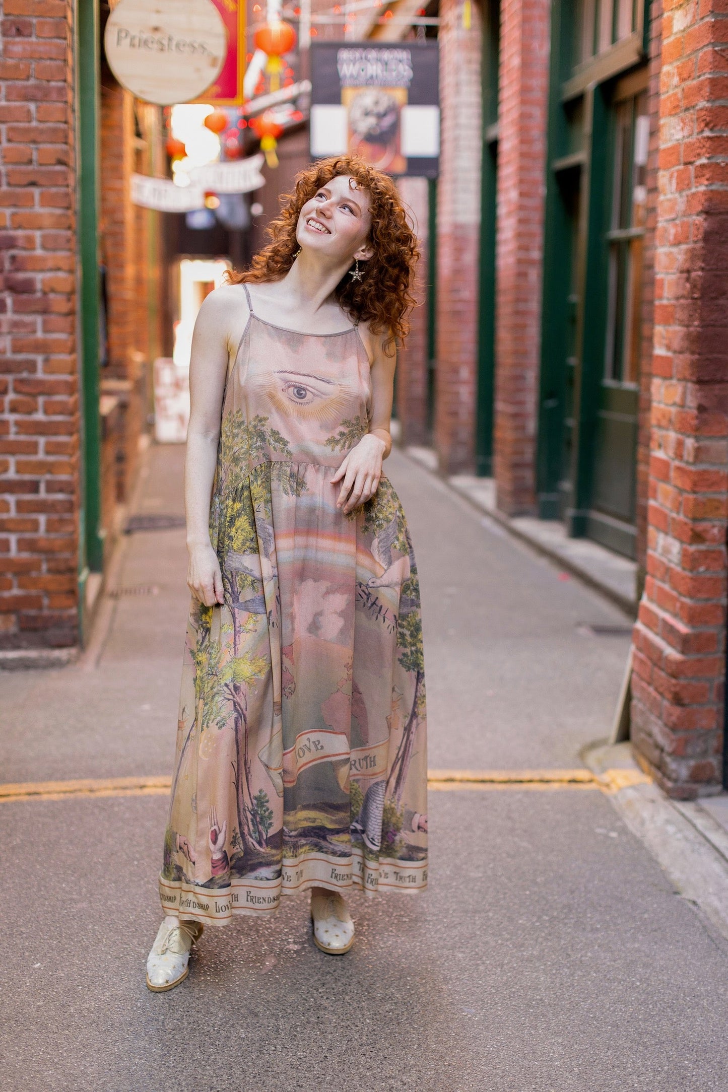 Model wearing sun-washed Bohéme slip dress featuring historic symbols of friendship, love, and truth in soft lavender, sage, gold, and aqua – Market of Stars.