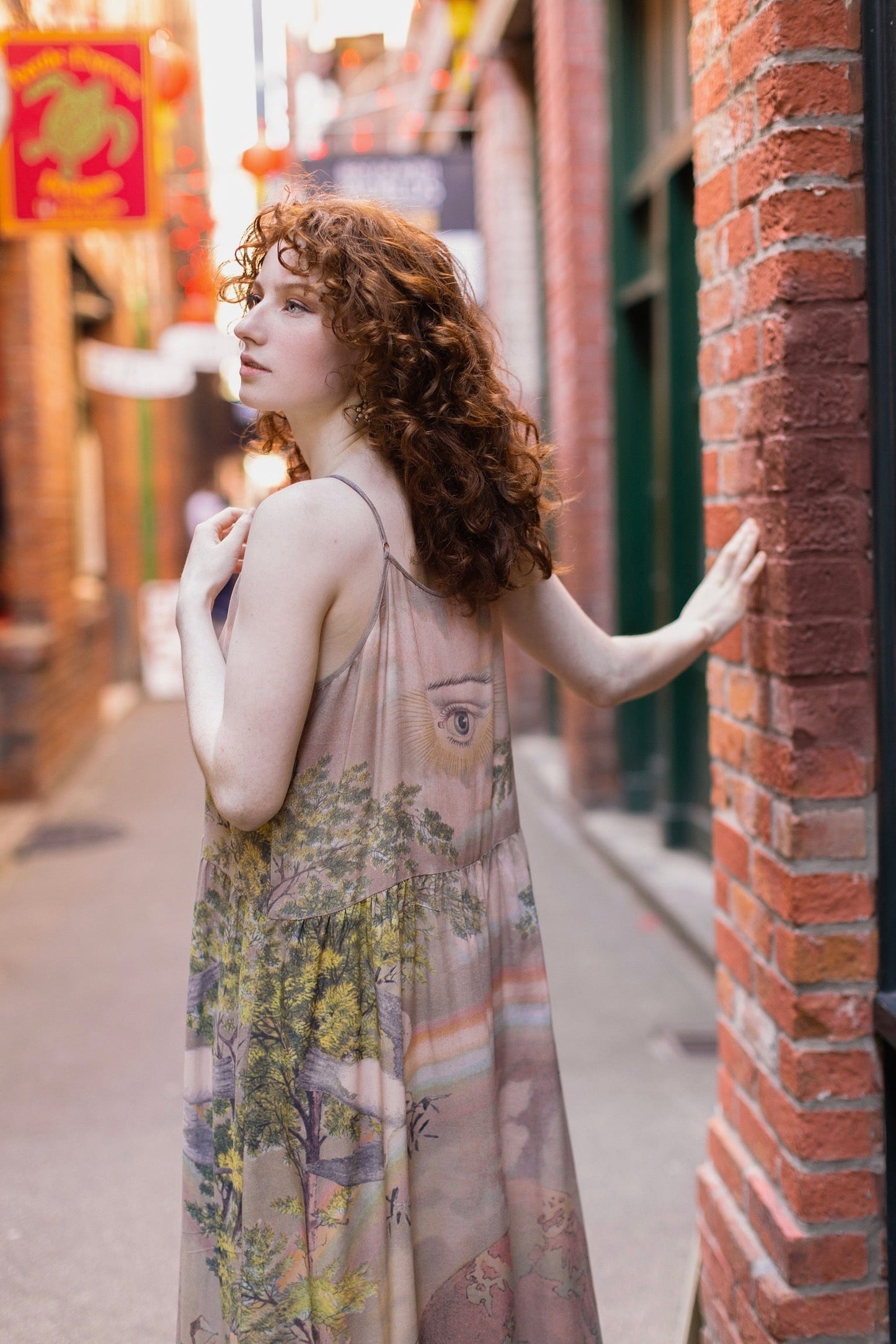 Model wearing sun-washed Bohéme slip dress featuring historic symbols of friendship, love, and truth in soft lavender, sage, gold, and aqua – Market of Stars.