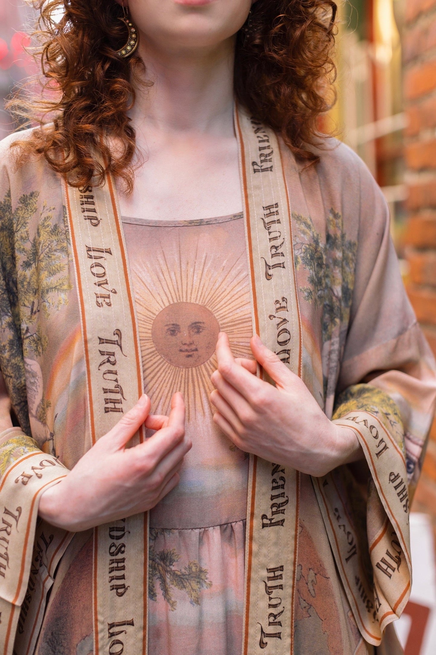Model wearing sun-washed vintage-inspired Opera Duster featuring symbols of friendship, love, and truth in soft lavender, sage, gold, and aqua – Market of Stars