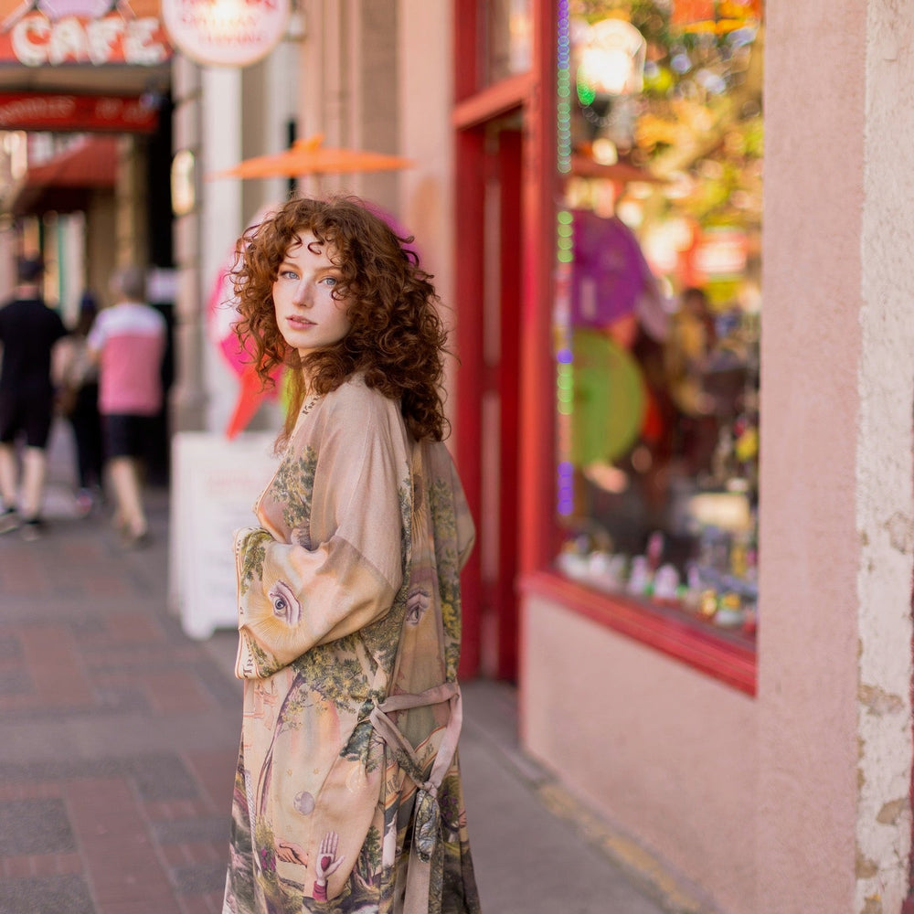 
                  
                    Model wearing sun-washed vintage-inspired Opera Duster featuring symbols of friendship, love, and truth in soft lavender, sage, gold, and aqua – Market of Stars
                  
                