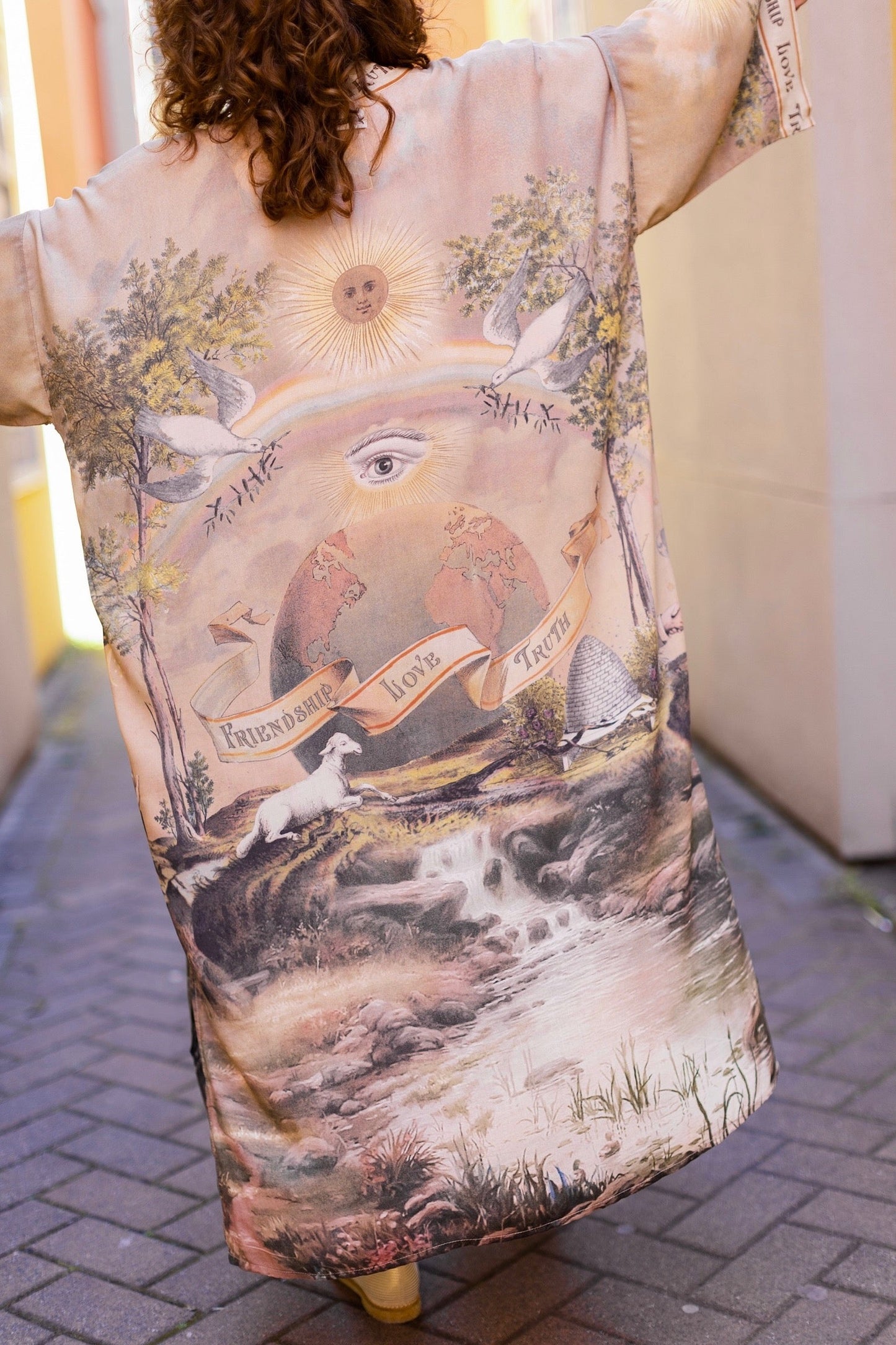 Model wearing sun-washed vintage-inspired Opera Duster featuring symbols of friendship, love, and truth in soft lavender, sage, gold, and aqua – Market of Stars