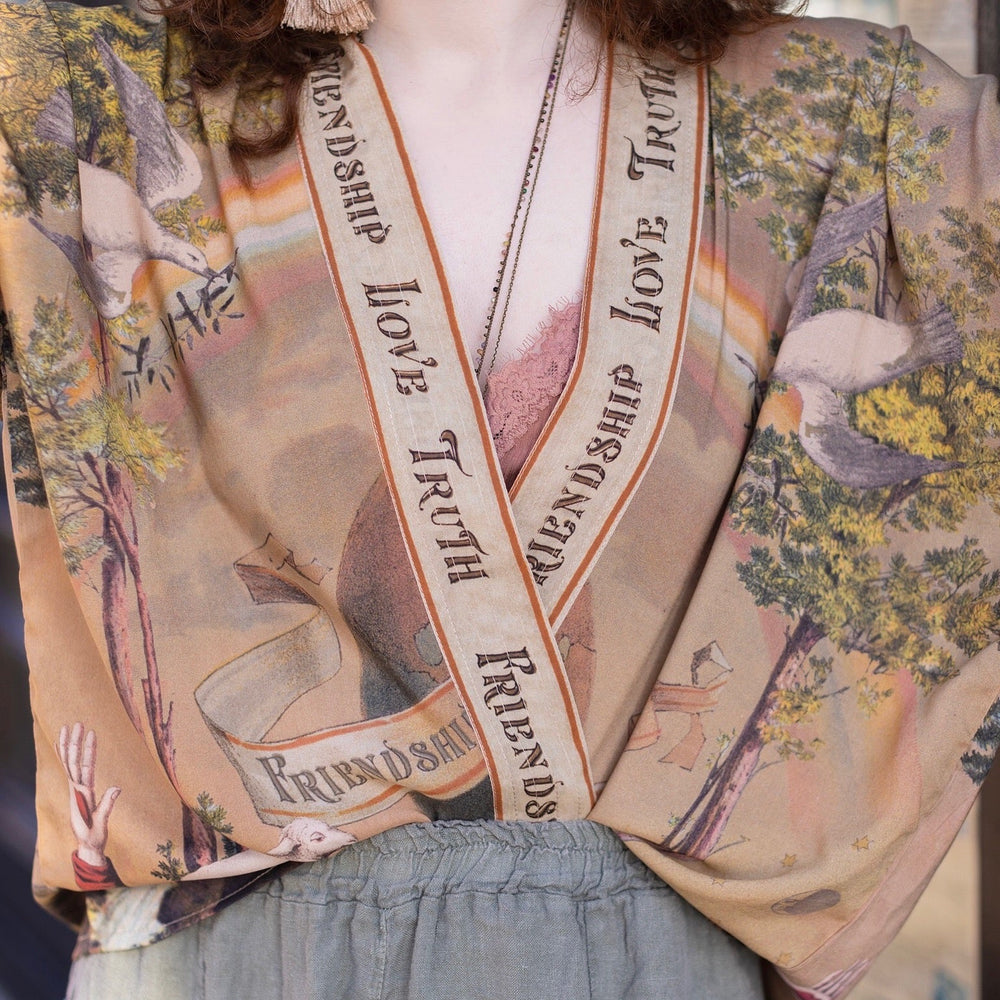 
                  
                    Vintage-inspired cropped kimono featuring historic symbols of friendship, love, and truth in a soft sun-washed palette of lavender, sage, gold, and aqua – Market of Stars.
                  
                