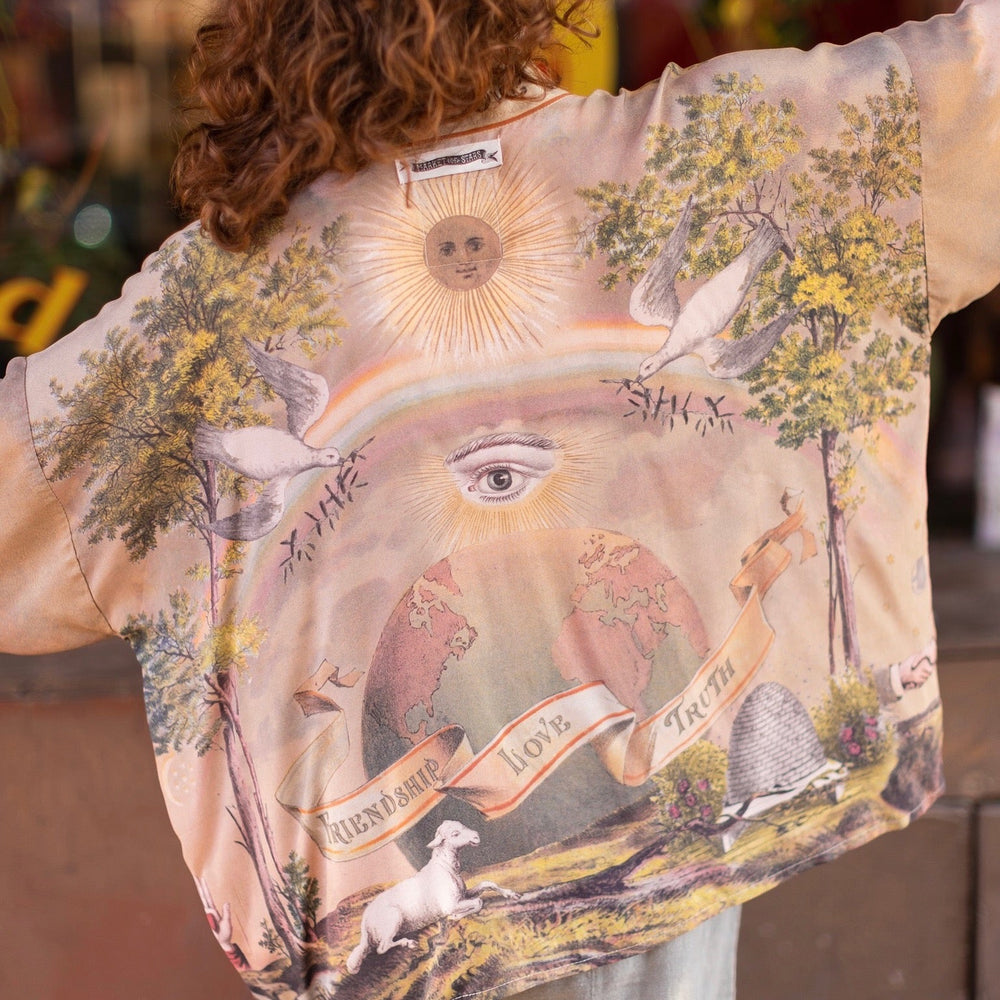 
                  
                    Vintage-inspired cropped kimono featuring historic symbols of friendship, love, and truth in a soft sun-washed palette of lavender, sage, gold, and aqua – Market of Stars.
                  
                