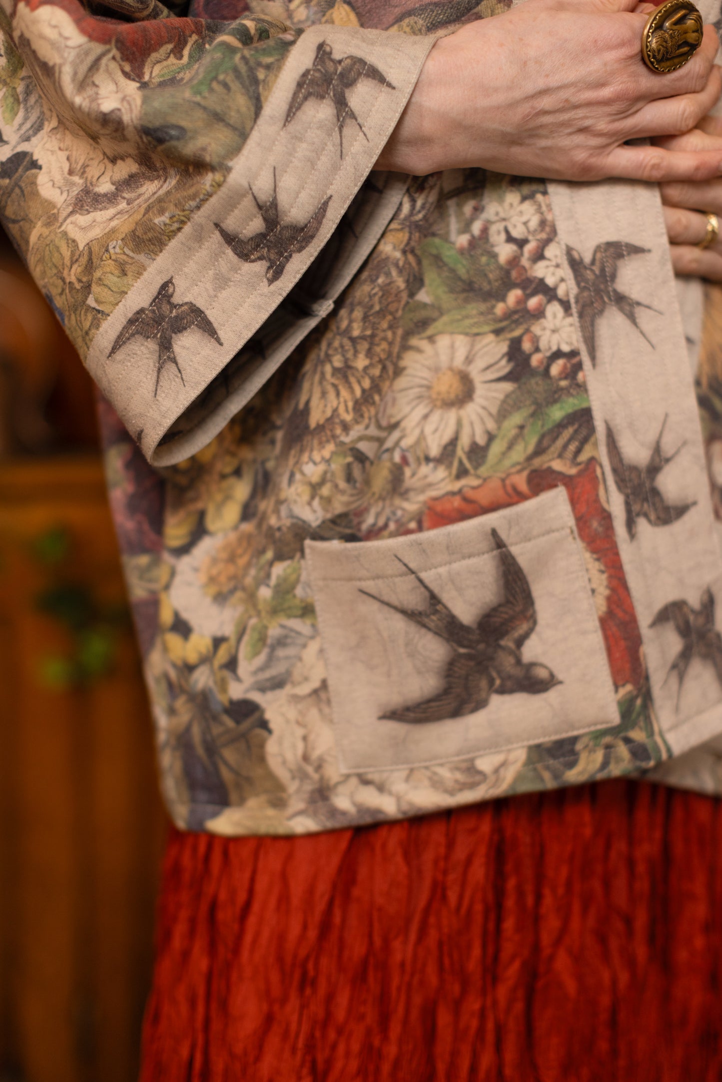 Model wearing a soft fleece cottage cardigan featuring rich 1700s botanical blooms and swallow trim - Market of Stars