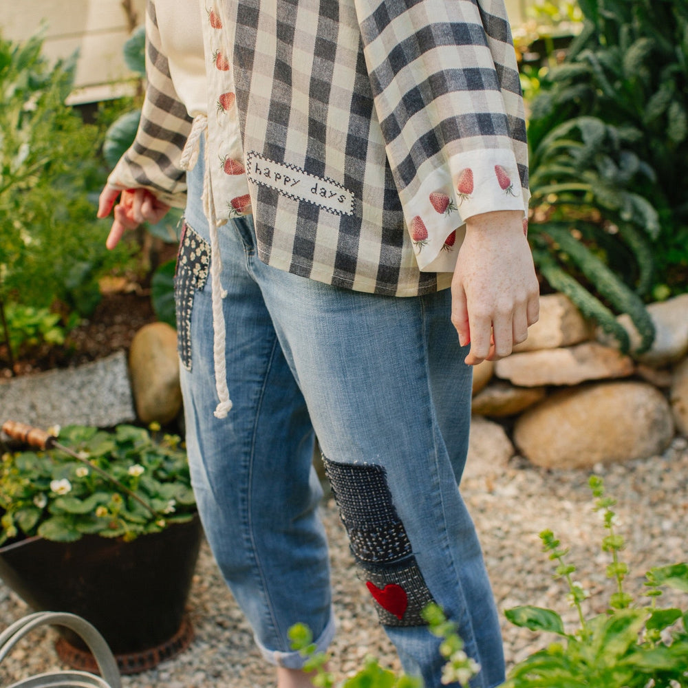 
                  
                    Model wearing Happy Days pixie cut kimono featuring heritage gingham, vintage strawberries, and a cross-stitch patch inspired by an 1836 sampler – Market of Stars.
                  
                