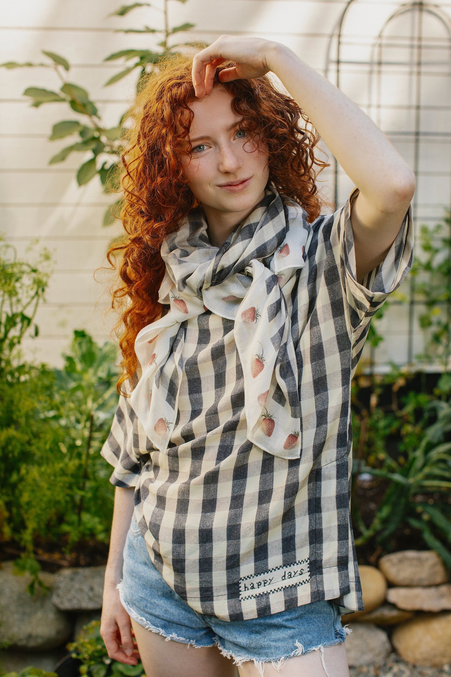 Model wearing Happy Days scarf featuring heritage gingham, vintage strawberries, and a cross-stitch patch inspired by an 1836 sampler – Market of Stars.