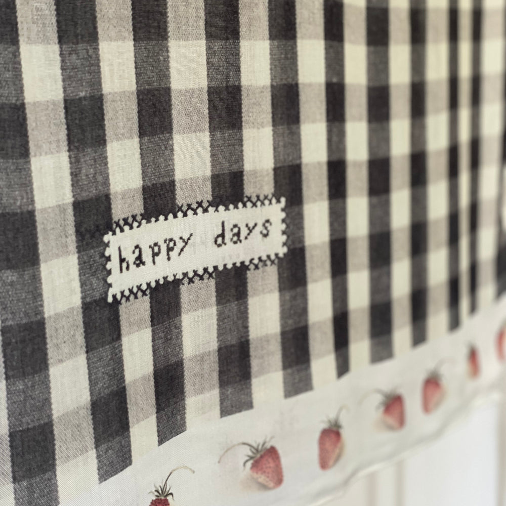 
                  
                    Model wearing Happy Days scarf featuring heritage gingham, vintage strawberries, and a cross-stitch patch inspired by an 1836 sampler – Market of Stars.
                  
                