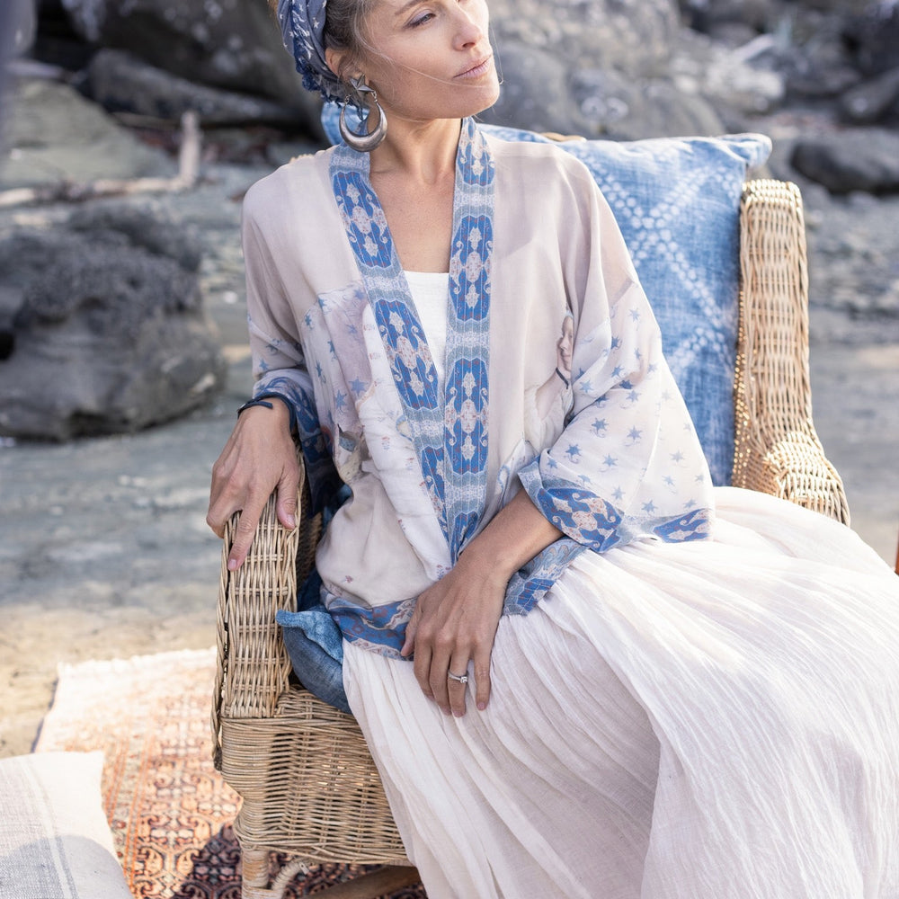 
                  
                    Model wearing the Head in the Clouds Opera Duster featuring Liotard’s portrait of his wife with Turkish textiles, starry sleeves, and poetic script – Market of Stars.
                  
                
