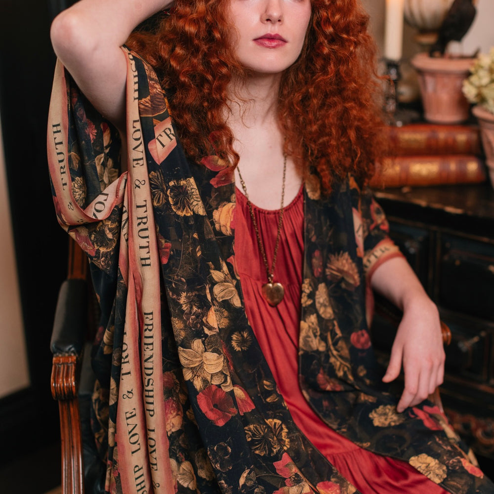
                  
                    Model wearing a flowy bamboo-viscose duster featuring a collage of antique artwork with romance, loyalty, and old-world beauty - Market of Stars
                  
                