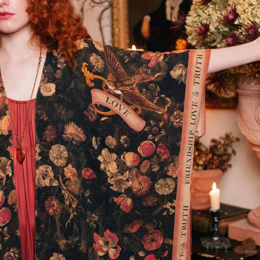 
                  
                    Model wearing a flowy bamboo-viscose duster featuring a collage of antique artwork with romance, loyalty, and old-world beauty - Market of Stars
                  
                