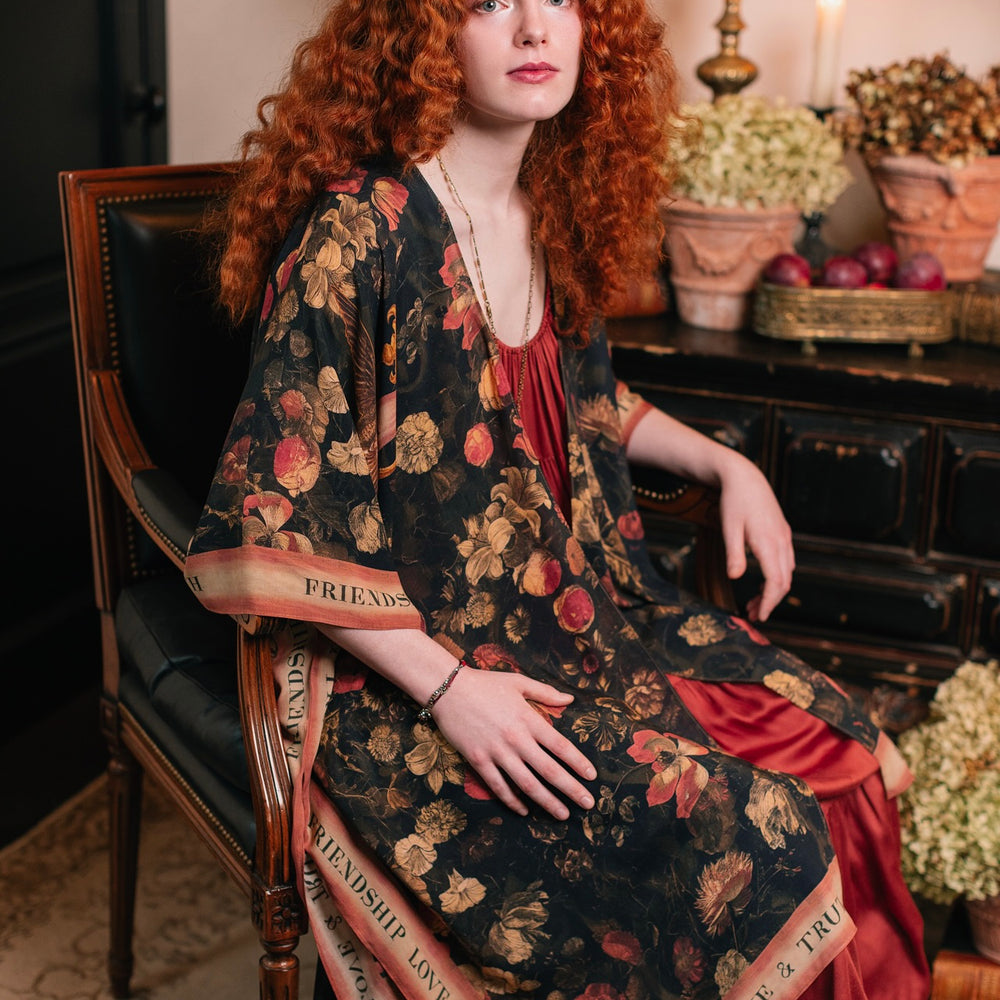 
                  
                    Model wearing a flowy bamboo-viscose duster featuring a collage of antique artwork with romance, loyalty, and old-world beauty - Market of Stars
                  
                