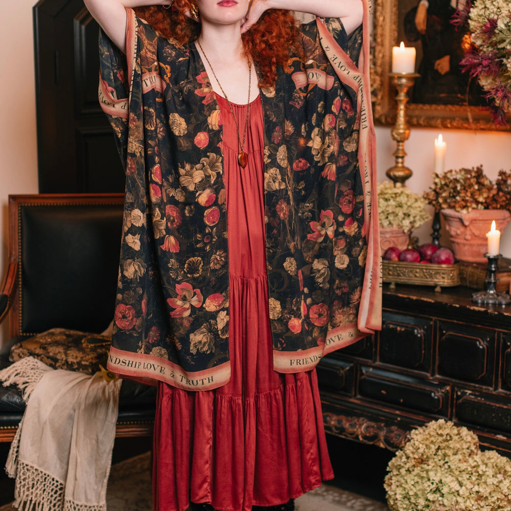 
                  
                    Model wearing a flowy bamboo-viscose duster featuring a collage of antique artwork with romance, loyalty, and old-world beauty - Market of Stars
                  
                