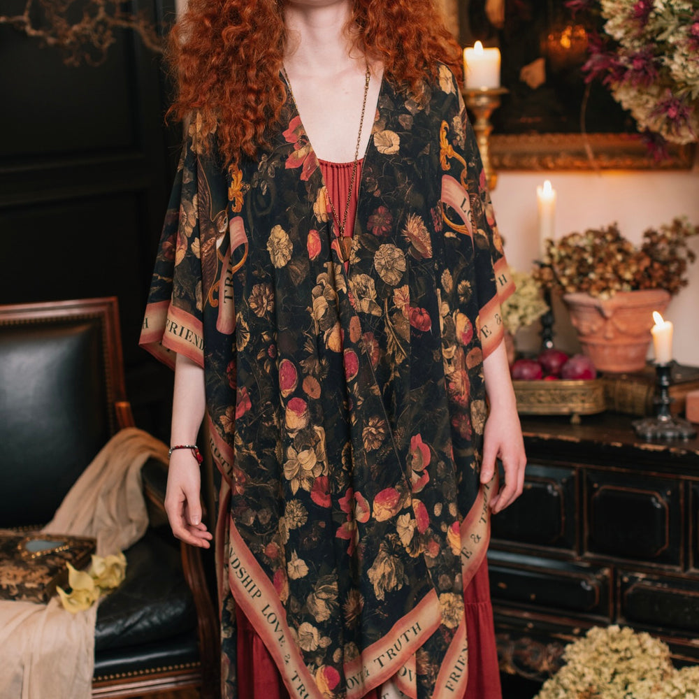 
                  
                    Model wearing a flowy bamboo-viscose duster featuring a collage of antique artwork with romance, loyalty, and old-world beauty - Market of Stars
                  
                