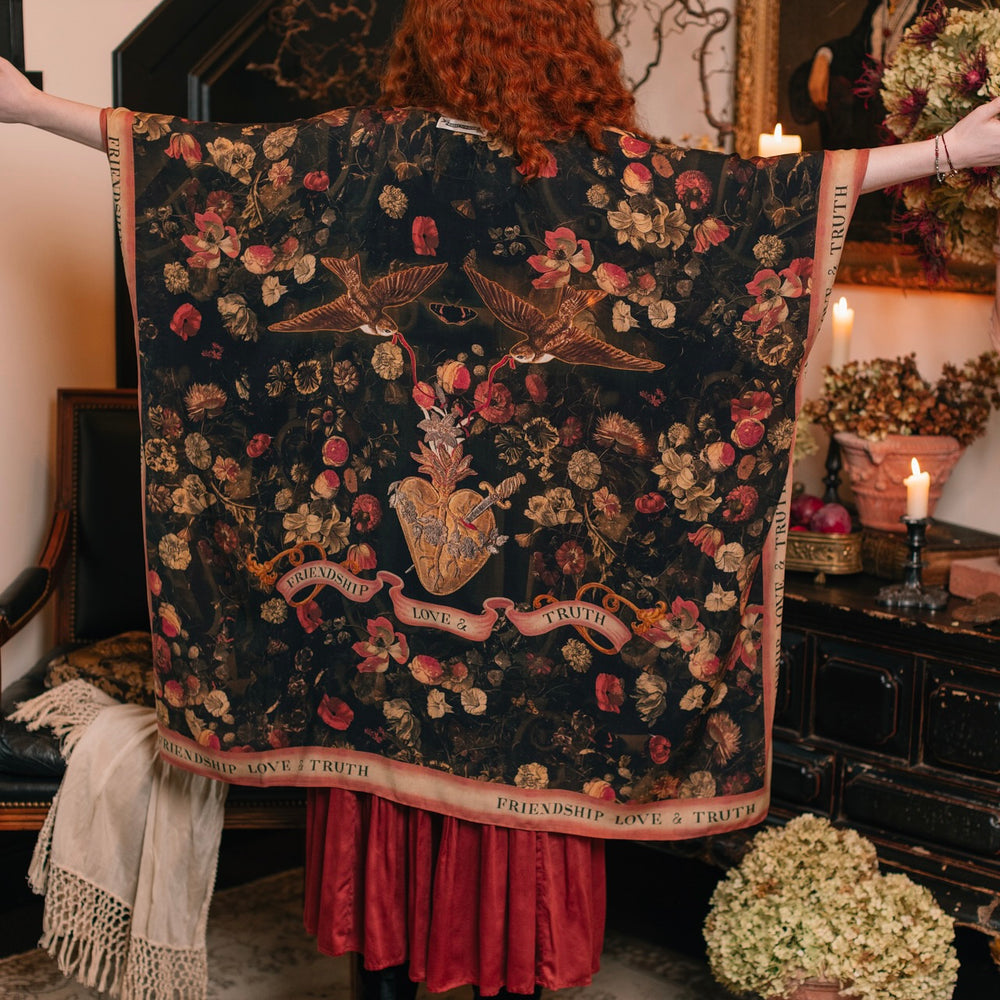 
                  
                    Model wearing a flowy bamboo-viscose duster featuring a collage of antique artwork with romance, loyalty, and old-world beauty - Market of Stars
                  
                