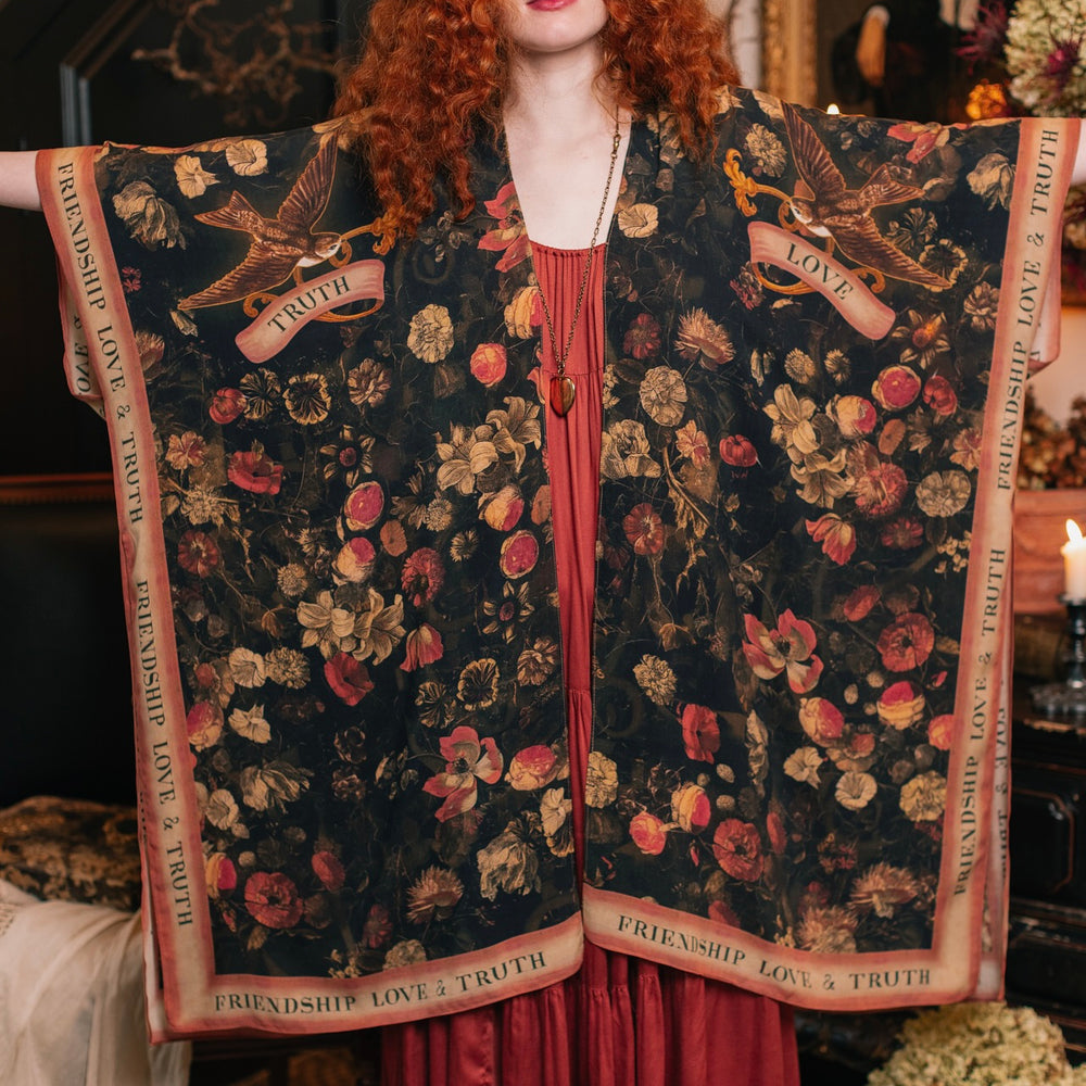 
                  
                    Model wearing a flowy bamboo-viscose duster featuring a collage of antique artwork with romance, loyalty, and old-world beauty - Market of Stars
                  
                