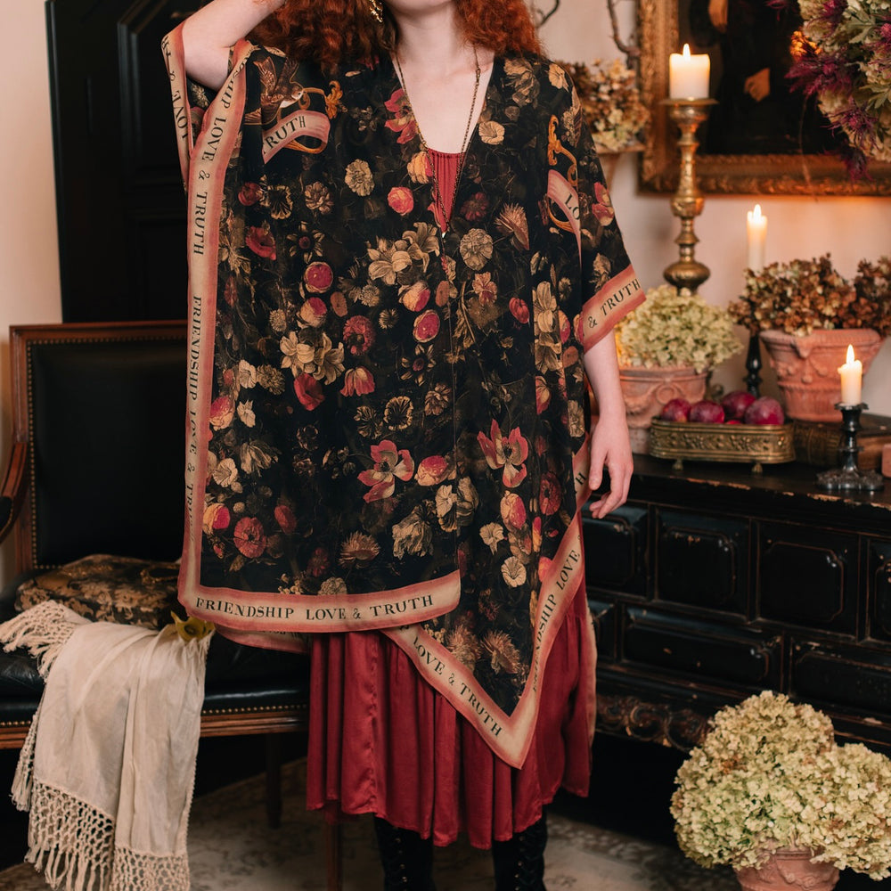 
                  
                    Model wearing a flowy bamboo-viscose duster featuring a collage of antique artwork with romance, loyalty, and old-world beauty - Market of Stars
                  
                
