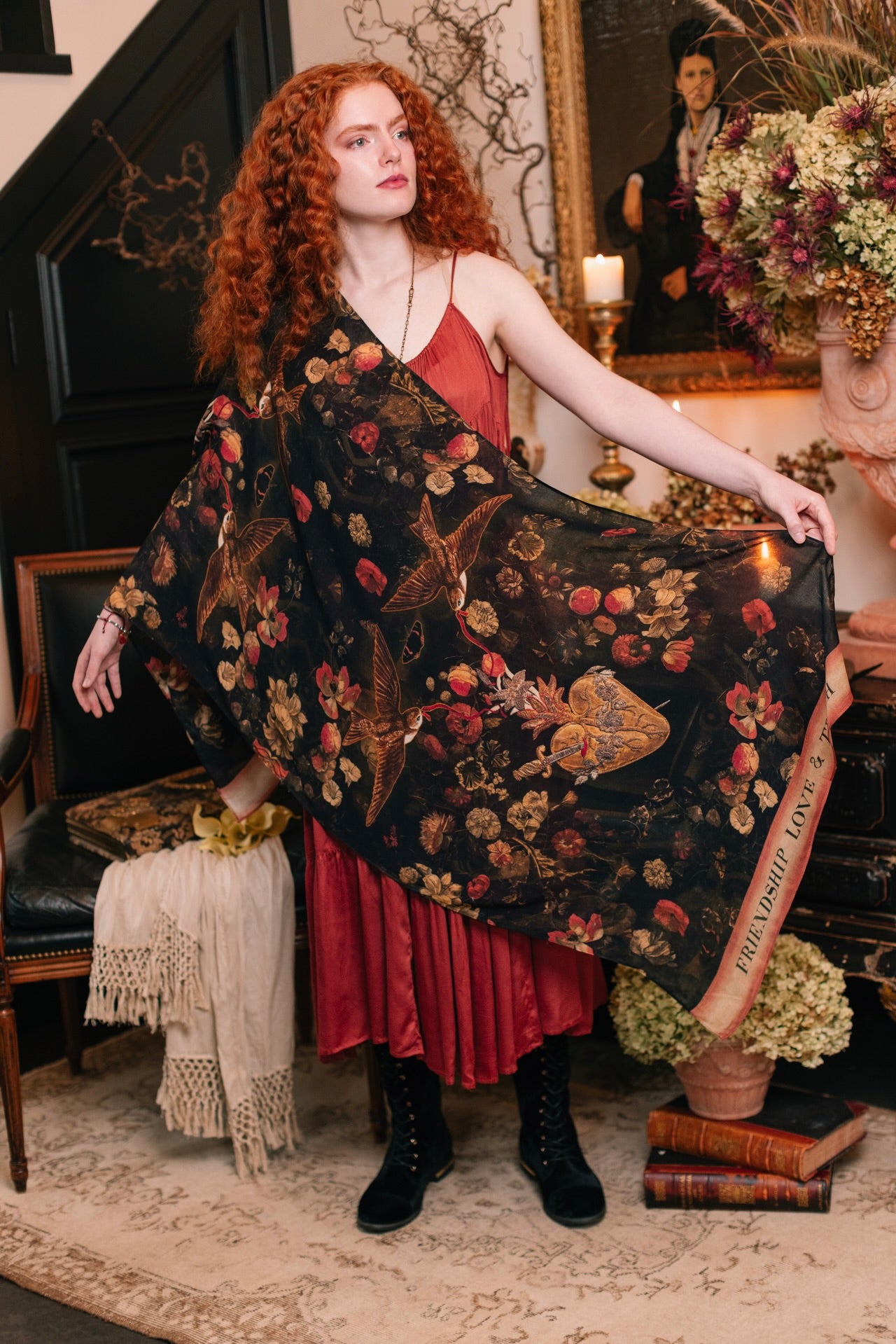 Model wearing a bamboo-viscose scarf featuring a collage of antique artwork that celebrates the bonds in our lives that endure — love, truth, and loyal friends!