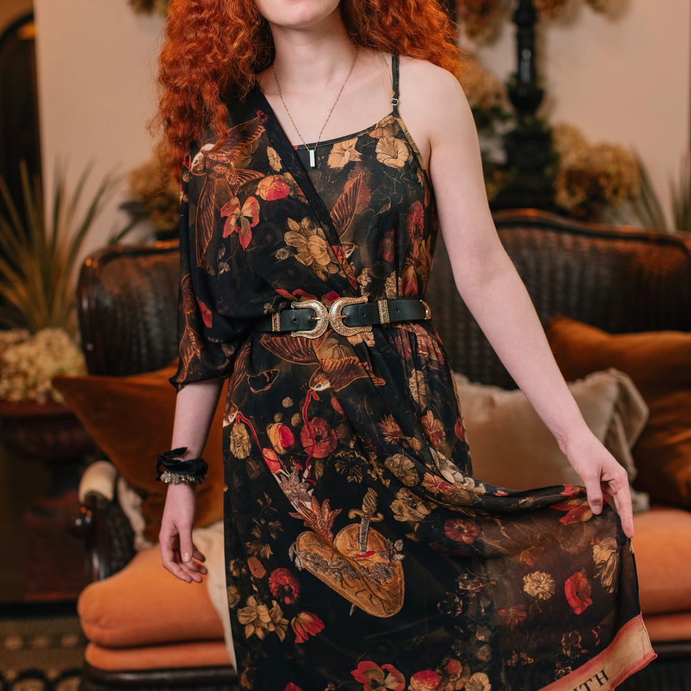 Model wearing a bamboo-viscose scarf featuring a collage of antique artwork that celebrates the bonds in our lives that endure — love, truth, and loyal friends!