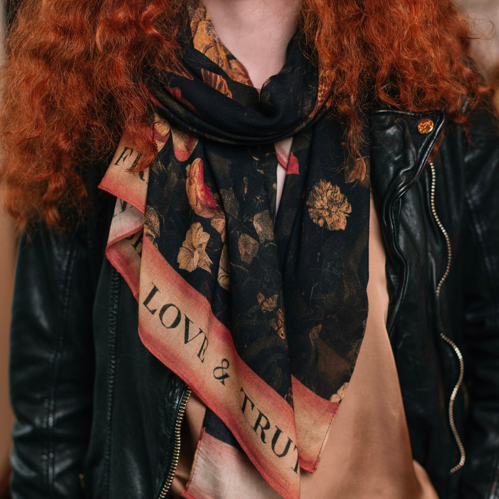
                  
                    Model wearing a bamboo-viscose scarf featuring a collage of antique artwork that celebrates the bonds in our lives that endure — love, truth, and loyal friends!
                  
                