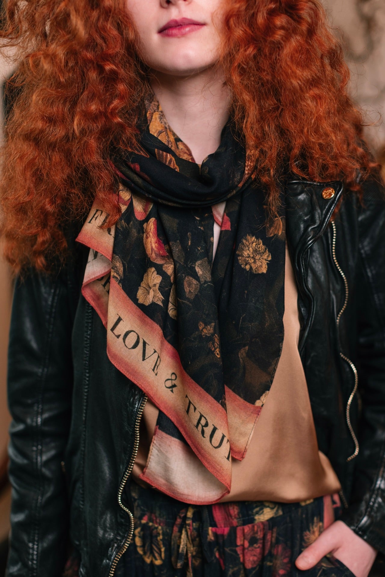 Model wearing a bamboo-viscose scarf featuring a collage of antique artwork that celebrates the bonds in our lives that endure — love, truth, and loyal friends!
