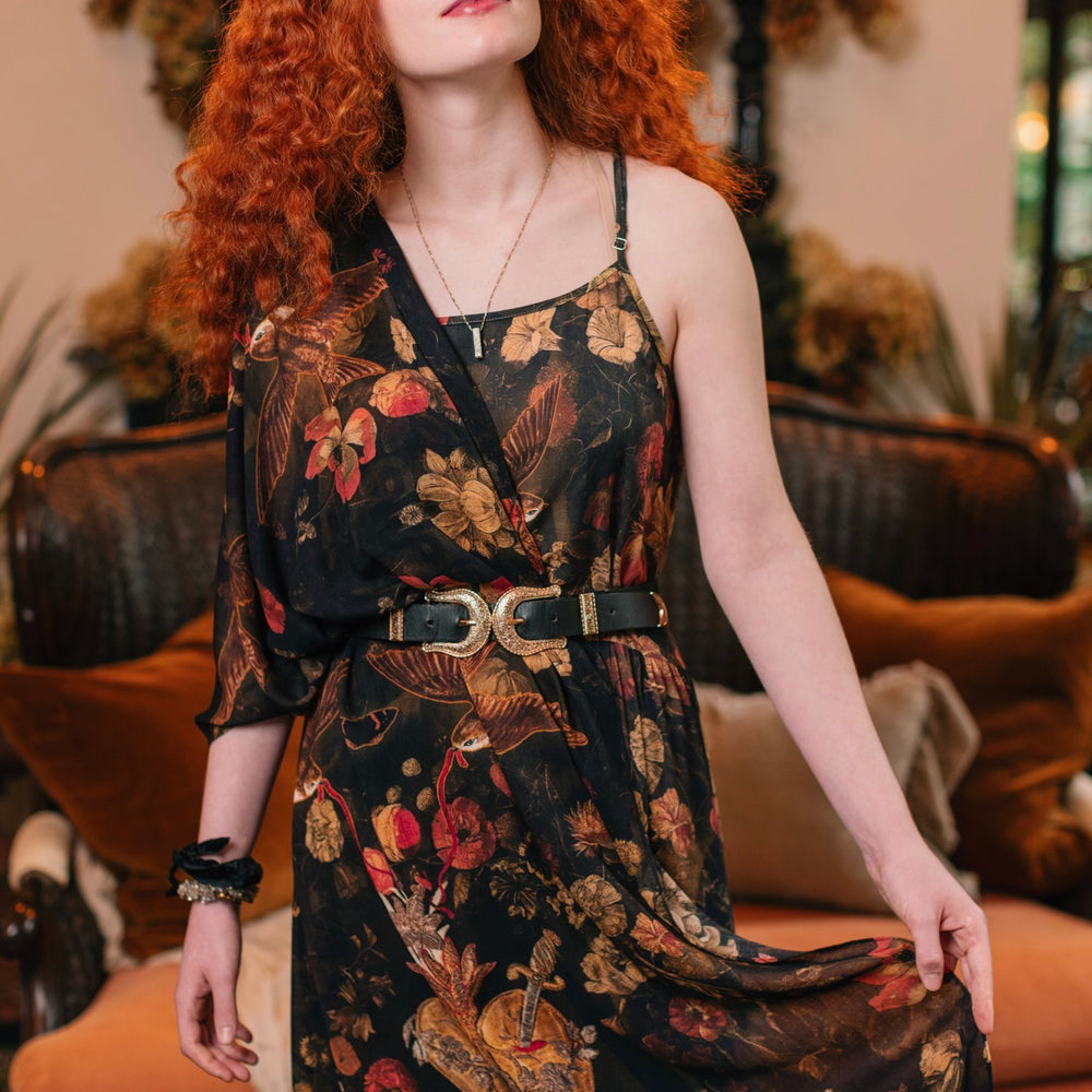 
                  
                    Model wearing a bamboo-viscose scarf featuring a collage of antique artwork that celebrates the bonds in our lives that endure — love, truth, and loyal friends!
                  
                